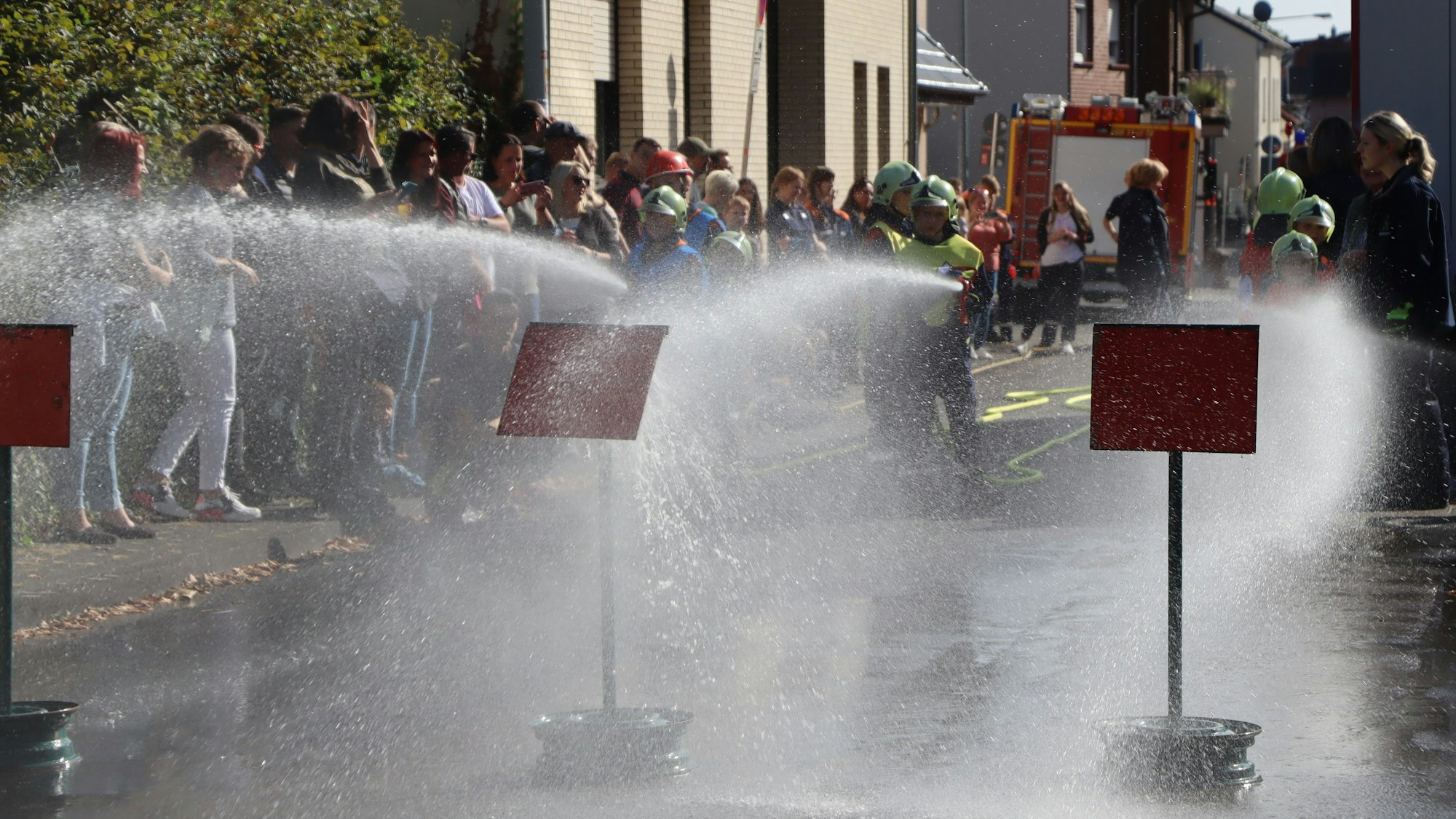 Feuerwehr-Kinder zeigen beim Okoberfest einen Löschangriff.