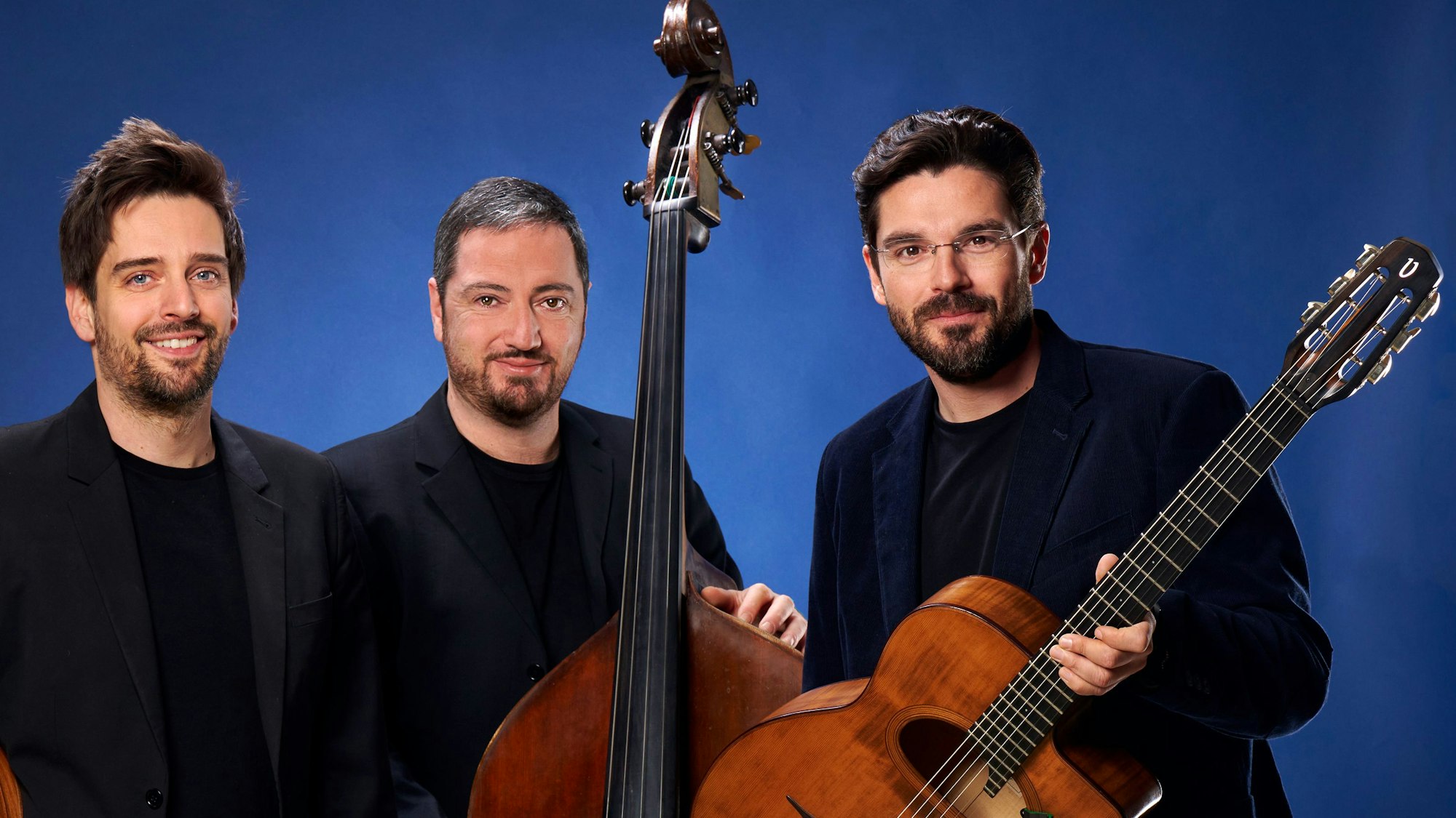 Das Joscho-Stephan-Trio: drei Musiker, alle in Schwarz gekleidet, mit ihren Instrumenten (Gitarre, Kontrabass).