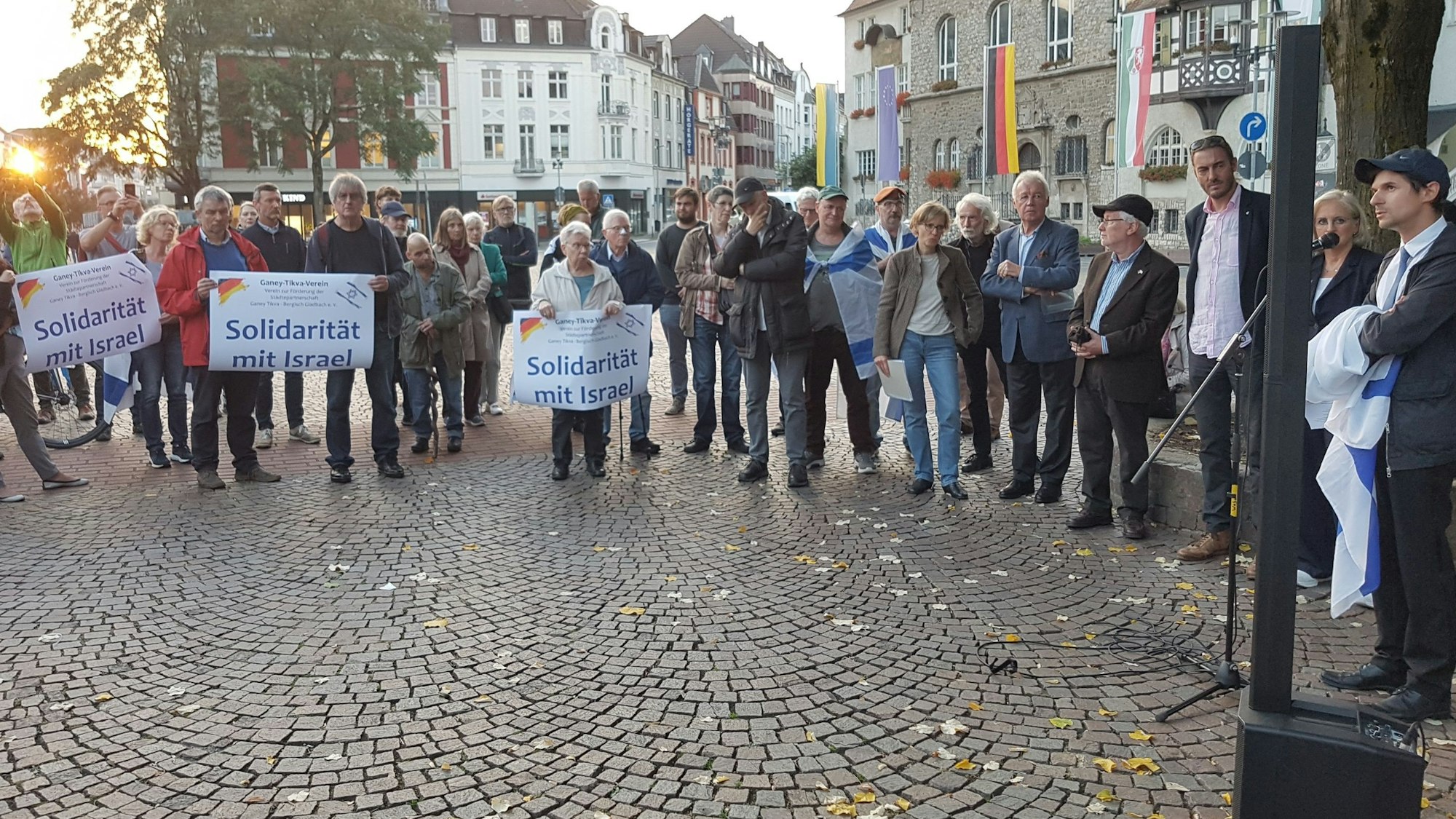 Auf dem Konrad-Adenauer-Platz demonstrieren Menschen mit Plakaten und Israel-Fahnen.