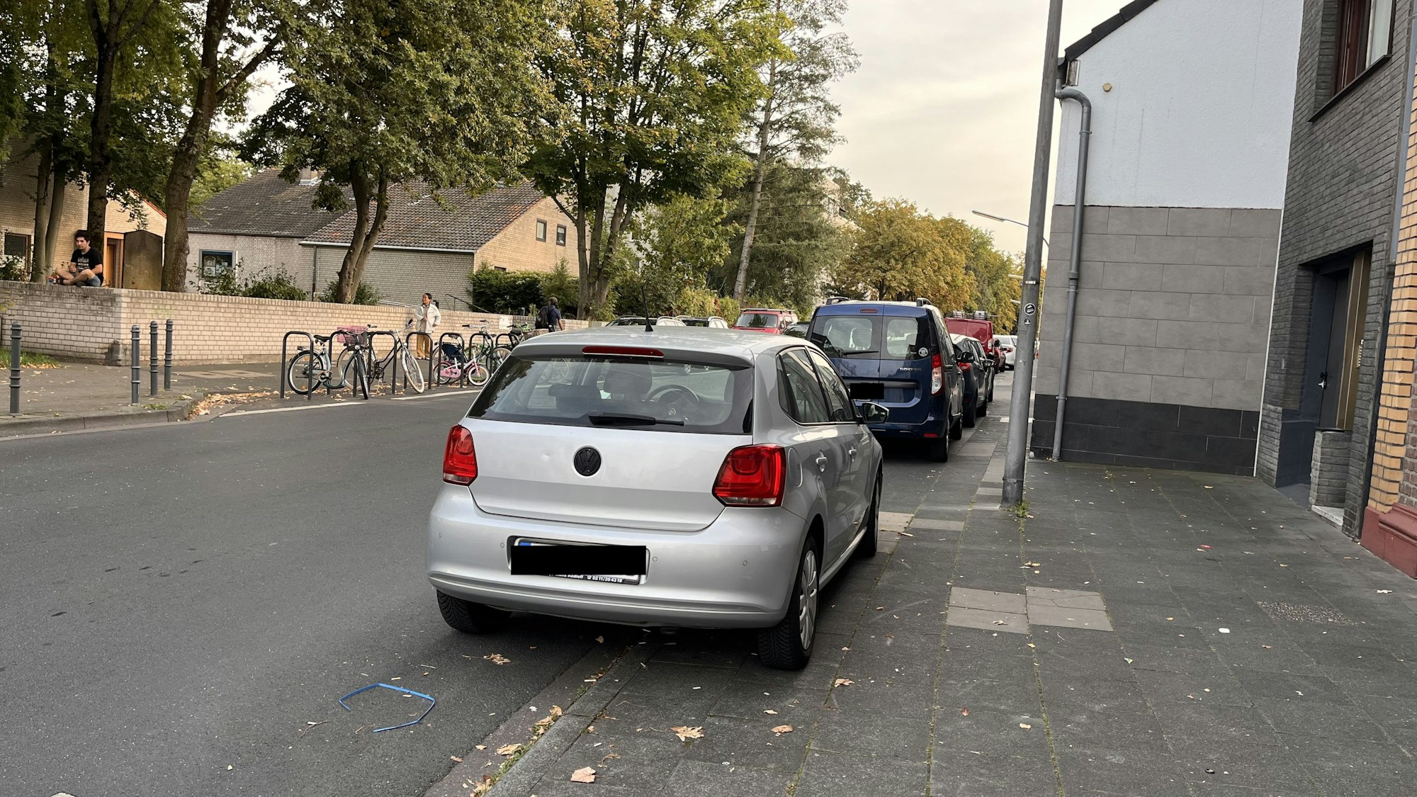 Parkende Autos behindern den Gehweg für kleinere Kinder auf den Fahrrädern.