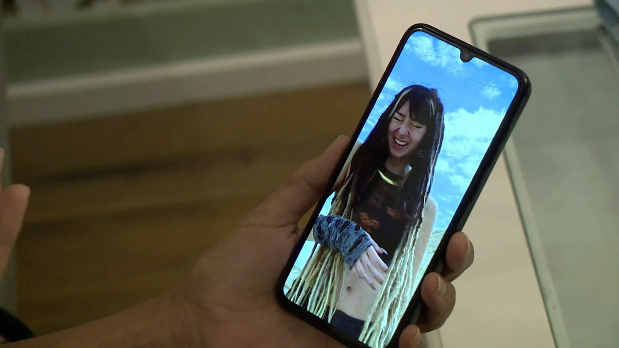 09.10.2023, Baden-Württemberg, Sulz am Neckar: Orly Louk, Tante der 22-jährigen Shani Louk, sitzt auf einer Couch und zeigt ein Handyfoto ihrer Nichte. In einer beispiellosen Aktion hatte die islamistische Hamas Israel am Samstag angegriffen, mehr als 1000 Menschen getötet und mehr als 100 Geiseln in den Gazastreifen verschleppt. Ziel der Angriffe war auch ein Musikfestival, das die 22-jährige Shani Louk nach Angaben ihrer Familie besucht hatte. Foto: David Pichler/TNN/dpa +++ dpa-Bildfunk +++