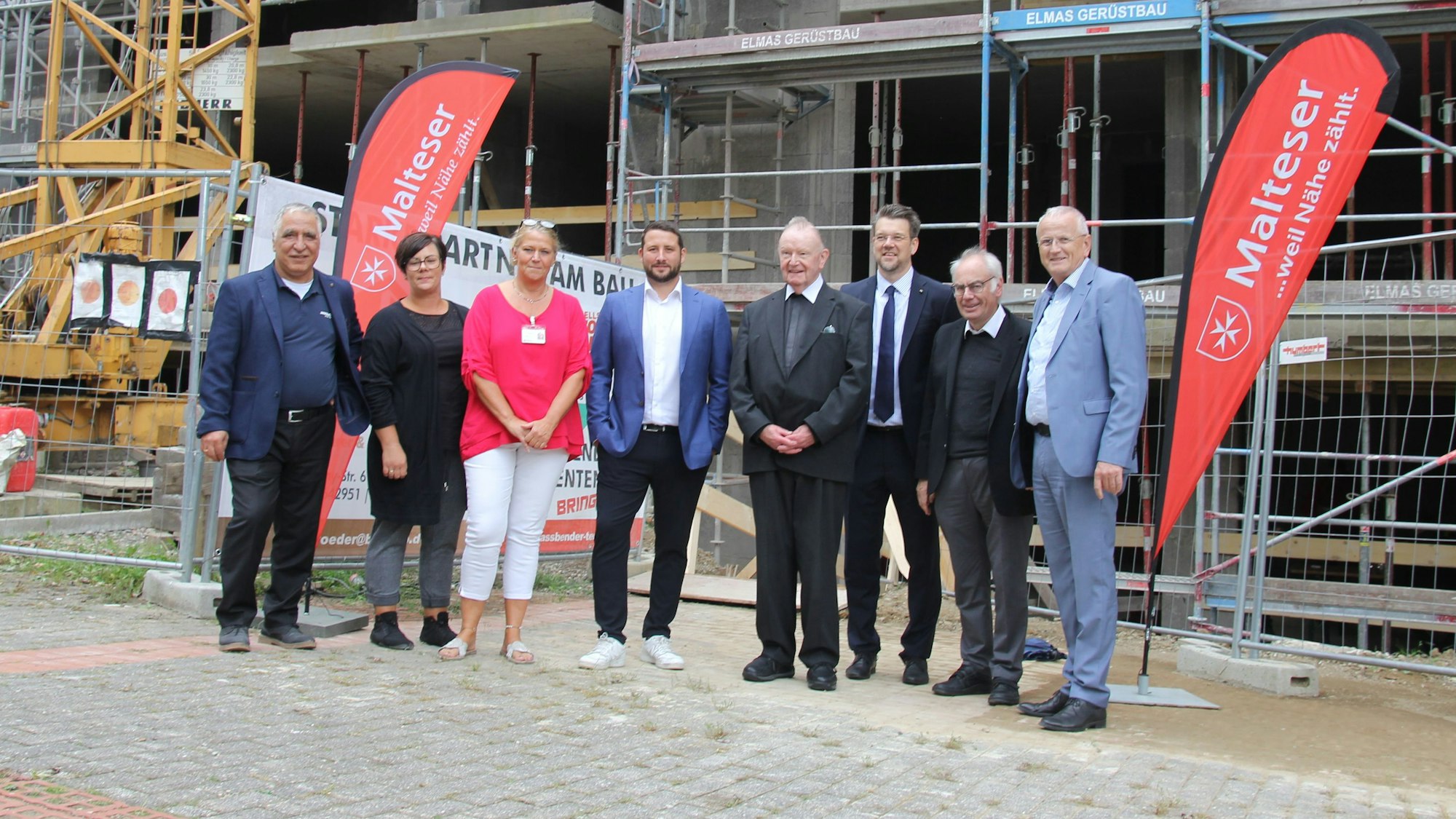 Architekt, Investor, Hausleitung und Overather Geistliche stehen vor der Baustelle.