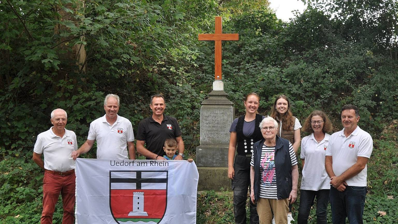 Bornheim-Uedorf. Das Unfallkreuz steht wieder. Ortsvorsteher Bernd Marx (rechts) bedankte sich bei Familie Lülsdorf und Zimmerin Katharina Rörig (5. von rechts) die die Gedenkstätte wiederhergestellt haben. Foto: Frank Engel-Strebel