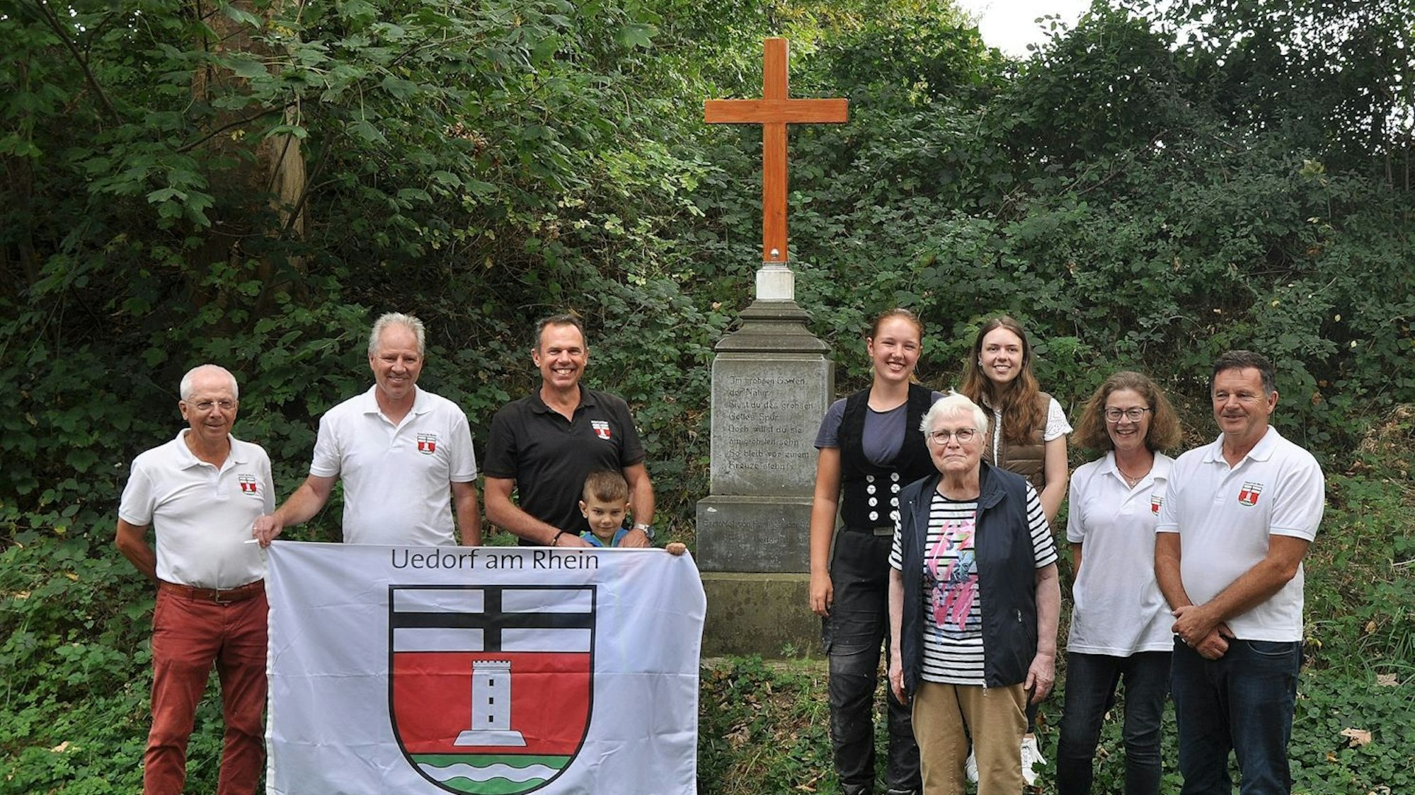 Bornheim-Uedorf. Das Unfallkreuz steht wieder. Ortsvorsteher Bernd Marx (rechts) bedankte sich bei Familie Lülsdorf und Zimmerin Katharina Rörig (5. von rechts) die die Gedenkstätte wiederhergestellt haben. Foto: Frank Engel-Strebel