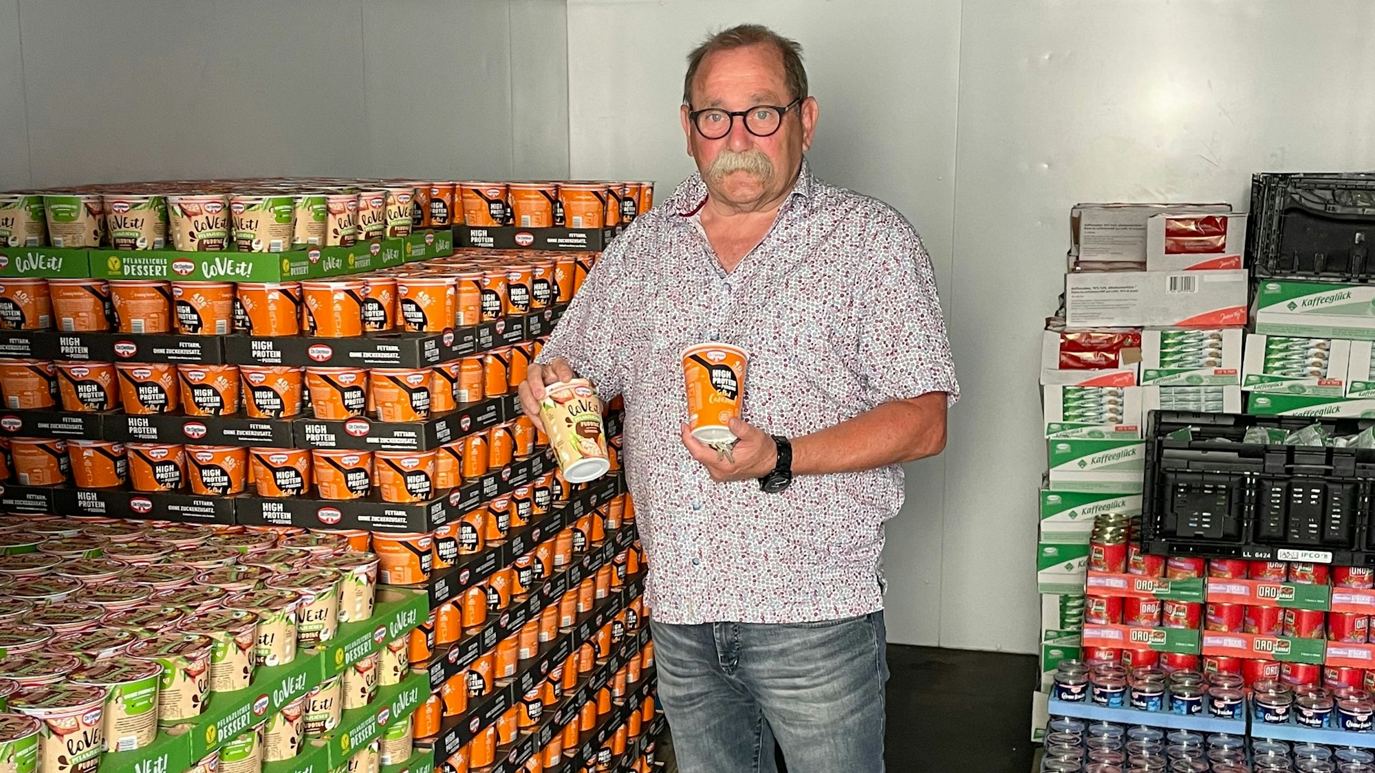 Der Vorsitzende der Mechernicher Tafel, Wolfgang Weilerswist, steht in einem Kühllager, umgeben von Dosen.