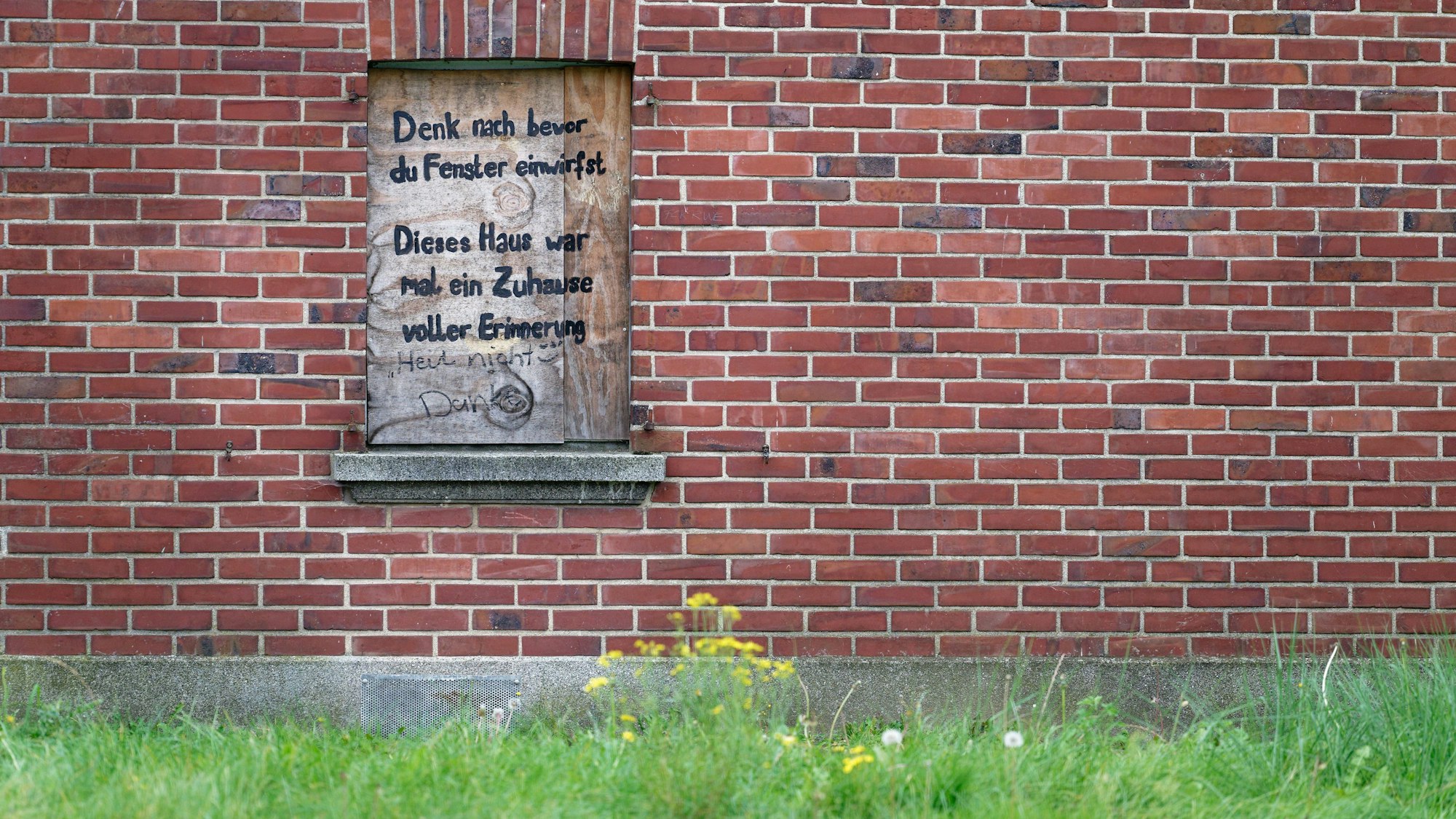 Erkelenz: Auf einem durch eine Holzplatte verschlossenem Fenster des ehemaligen Wohnhauses von Jennifer in Keyenberg steht: „Denk nach bevor du eine Fenster einwirfst. Dieses Haus war mal ein Zuhause voller Erinnerung“