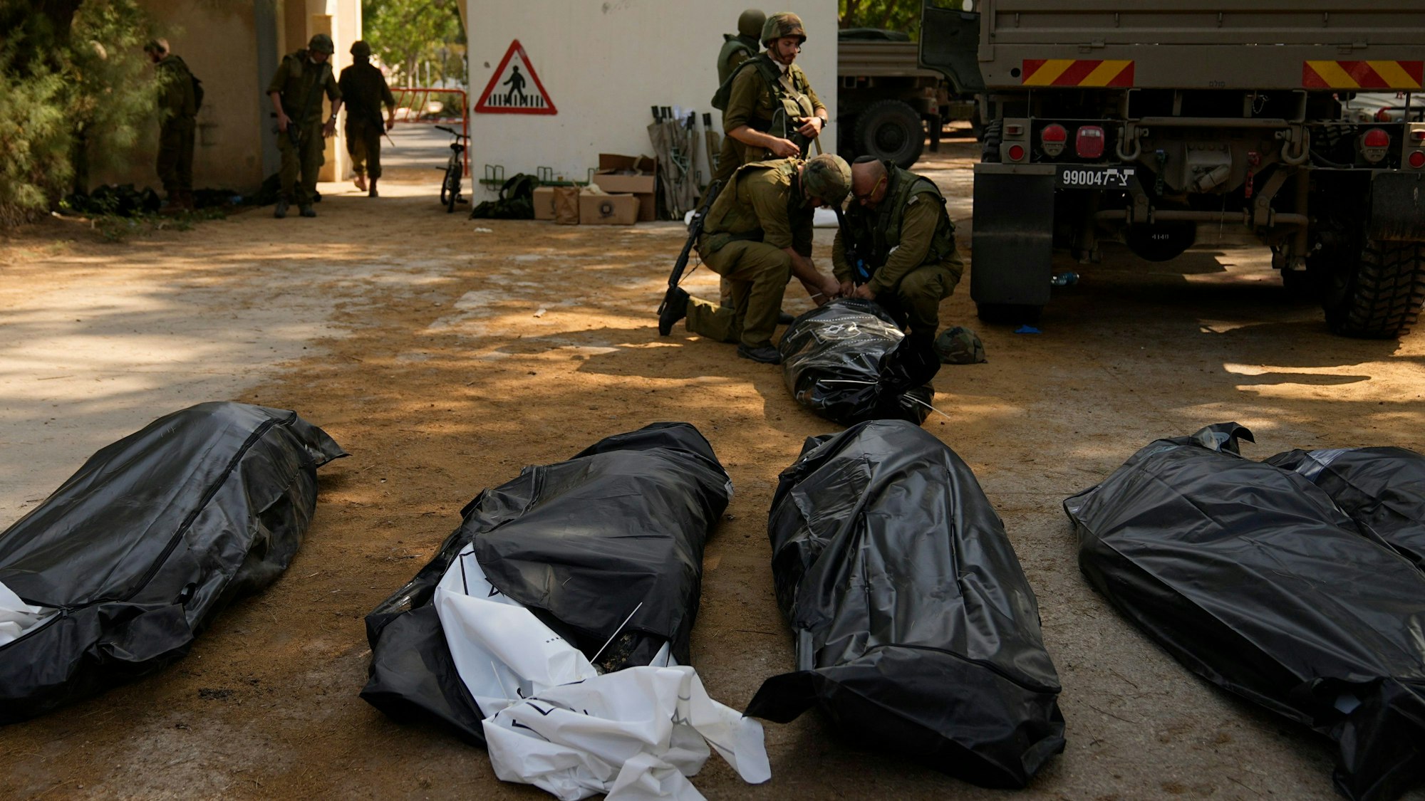 Israelische Soldaten bergen am Dienstag Leichen von getöteten Zivilisten im Kibbuz Kfar Azza. Hamas-Terroristen begingen in vielen israelischen Siedlungen am Samstag Gräueltaten. Viele Menschen werden weiterhin vermisst.