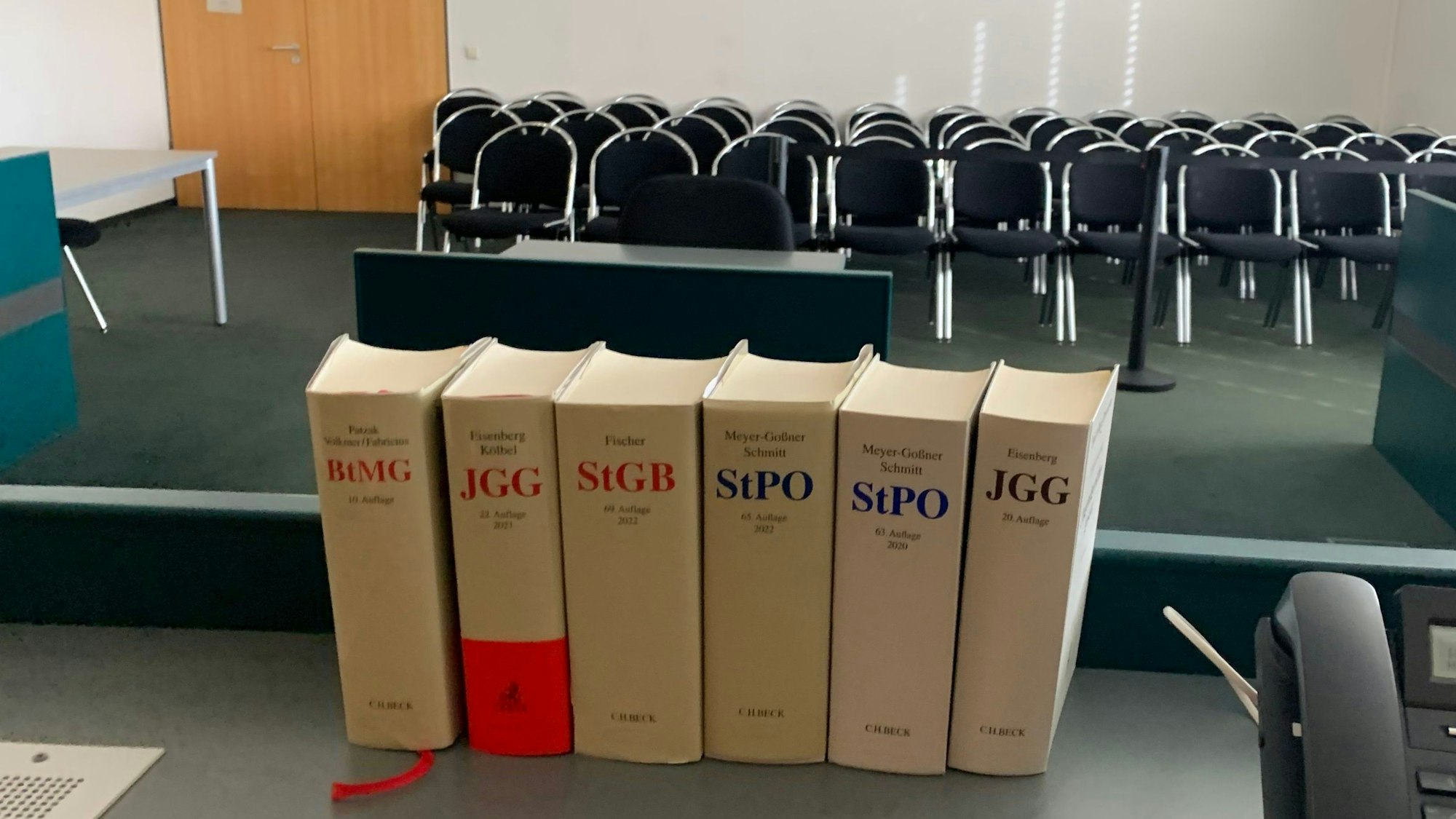 Das Symbolbild zeigt einen Sitzungssaal des Euskirchener Amtsgerichts, im Vordergrund Bücher mit Gesetzestexten.