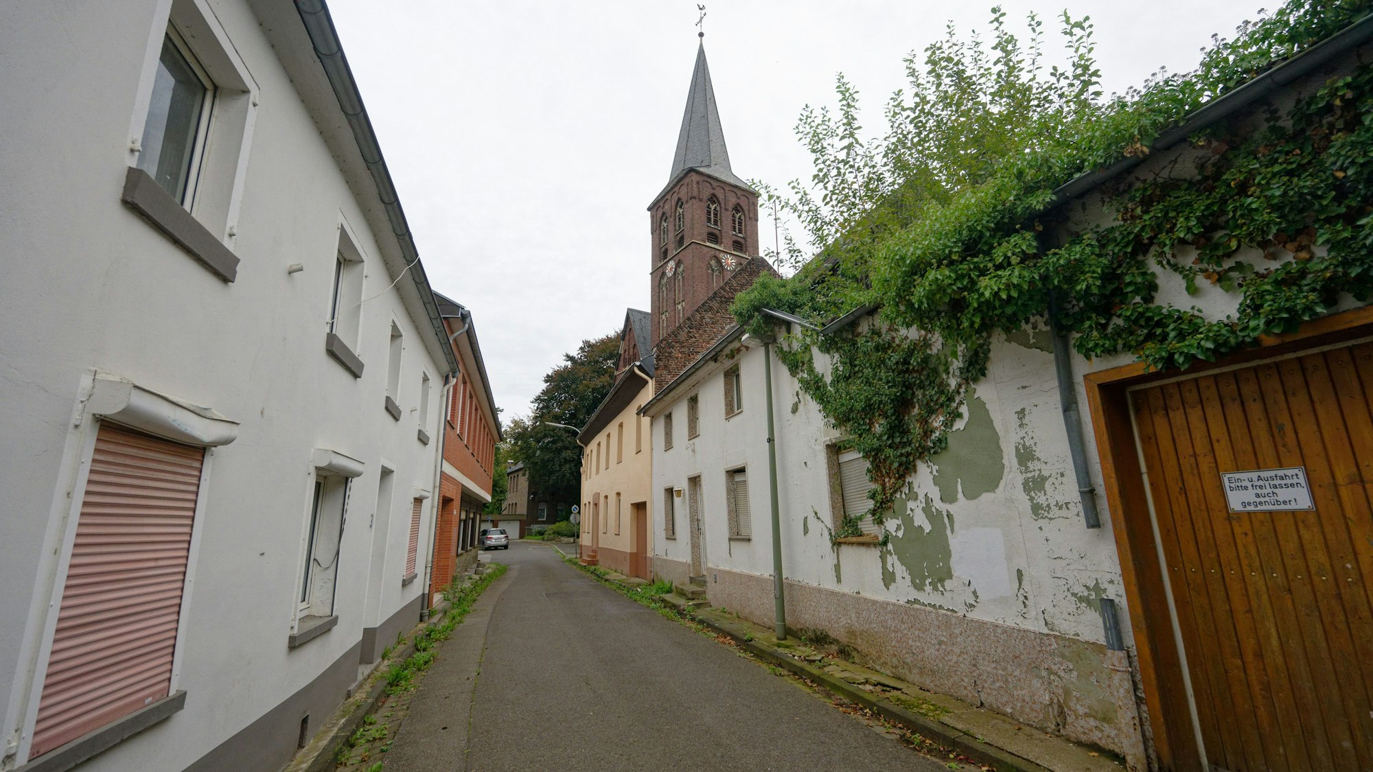 Leere Häuser stehen an der Straße ‚An Sankt Kreuz‘ in Keyenberg. Die Jahre des Leerstands zeichnen Keyenberg am Tagebau Garzweiler.