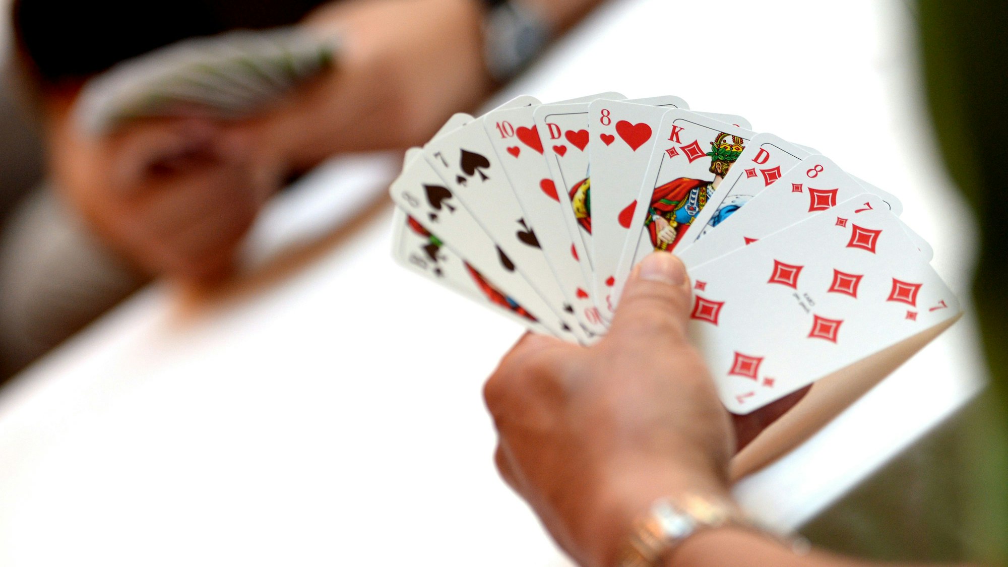 Ein Spieler hält Skatkarten in der Hand (Symbolbild).