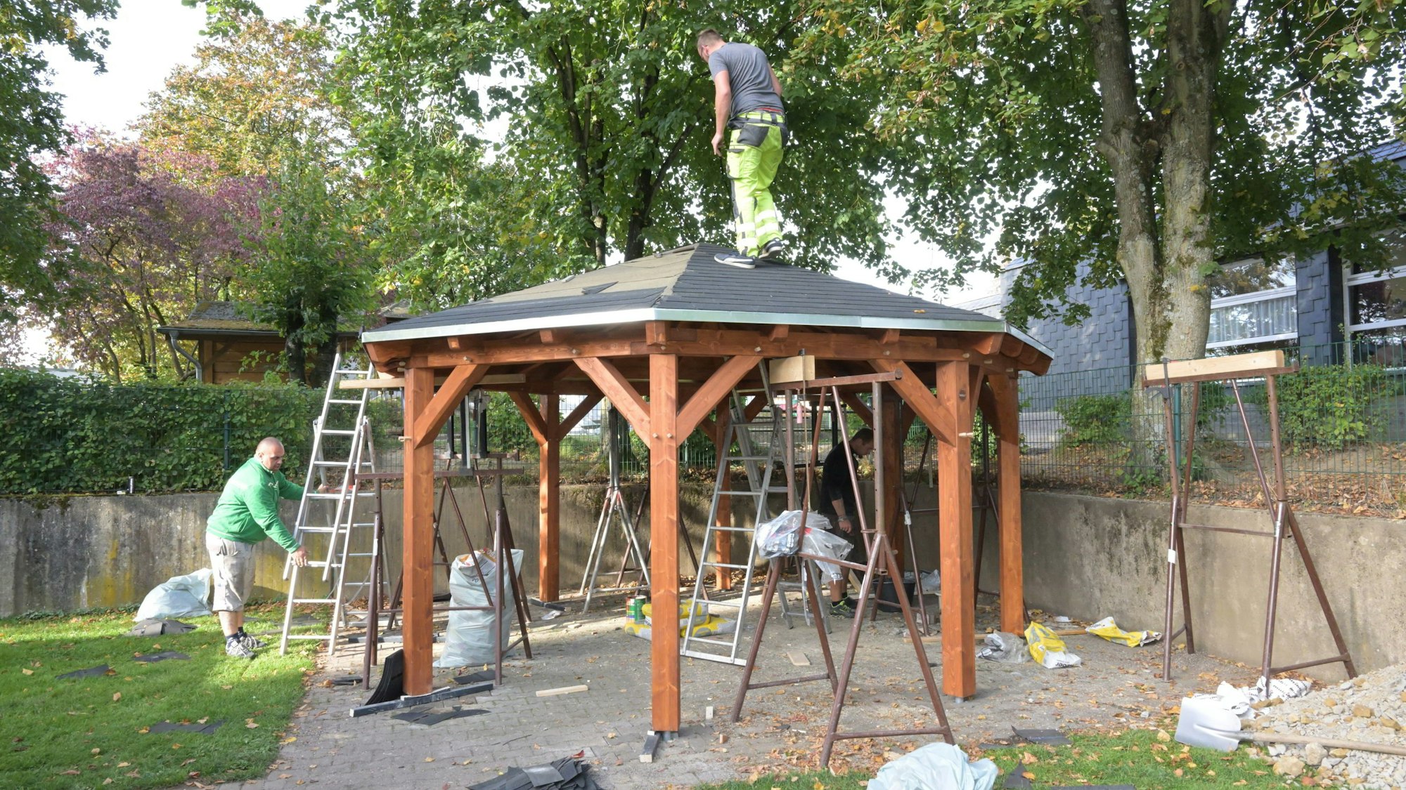 Handwerker bauen an einem achteckigen Pavillon.