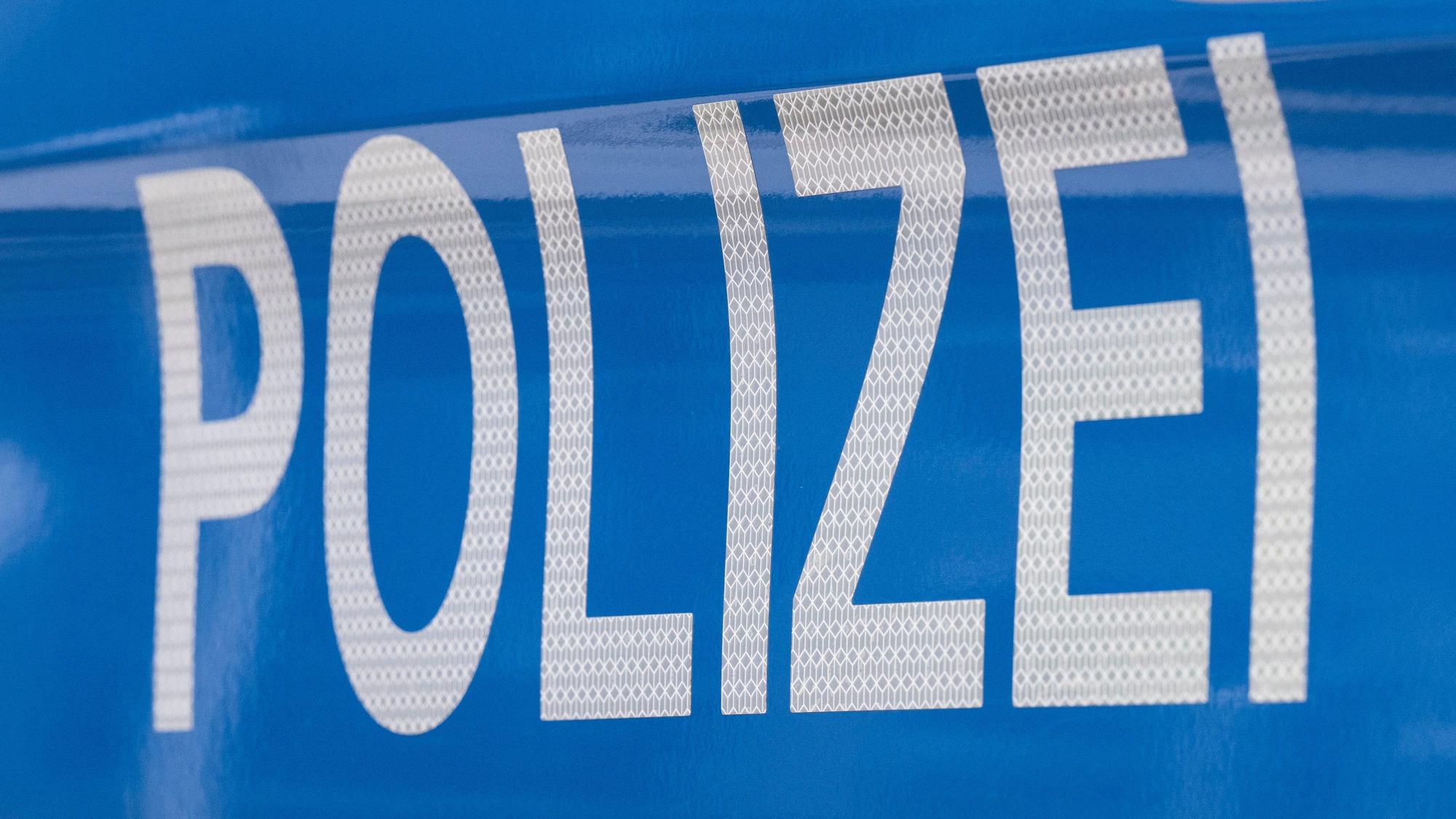 Der Schriftzug ·Polizei· ist auf einem Streifenwagen zu lesen.