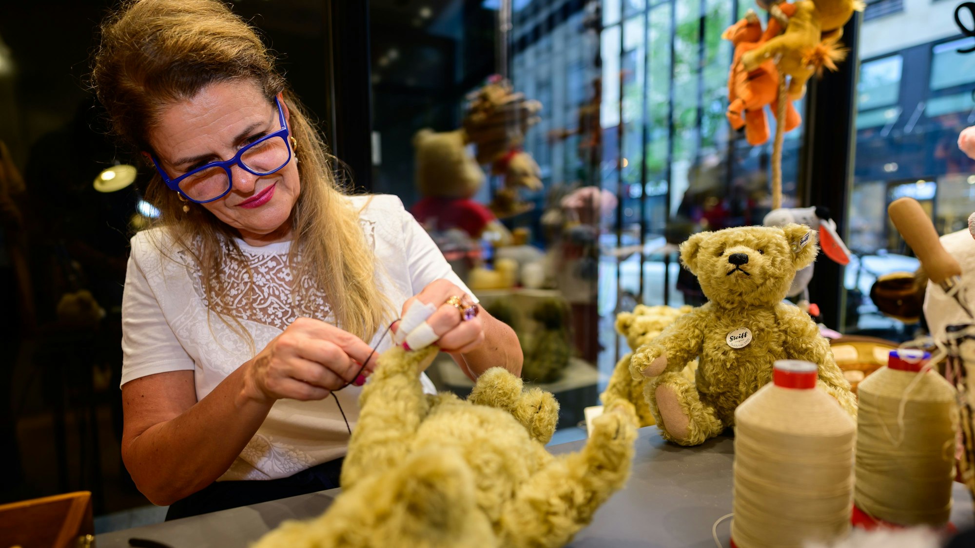 Sunnhild Walzer näht einem Bären die Krallen an.