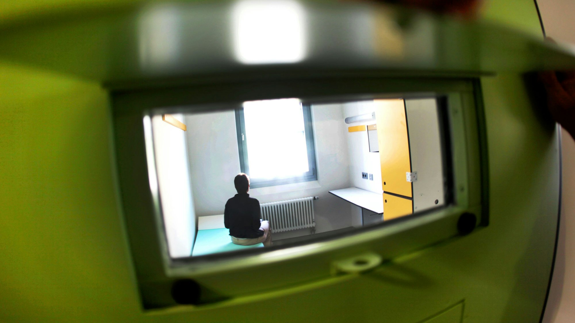 Blick in eine Zelle in der Justizvollzugsanstalt Wuppertal-Ronsdorf, aufgenommen durch eine Klappe hindurch.