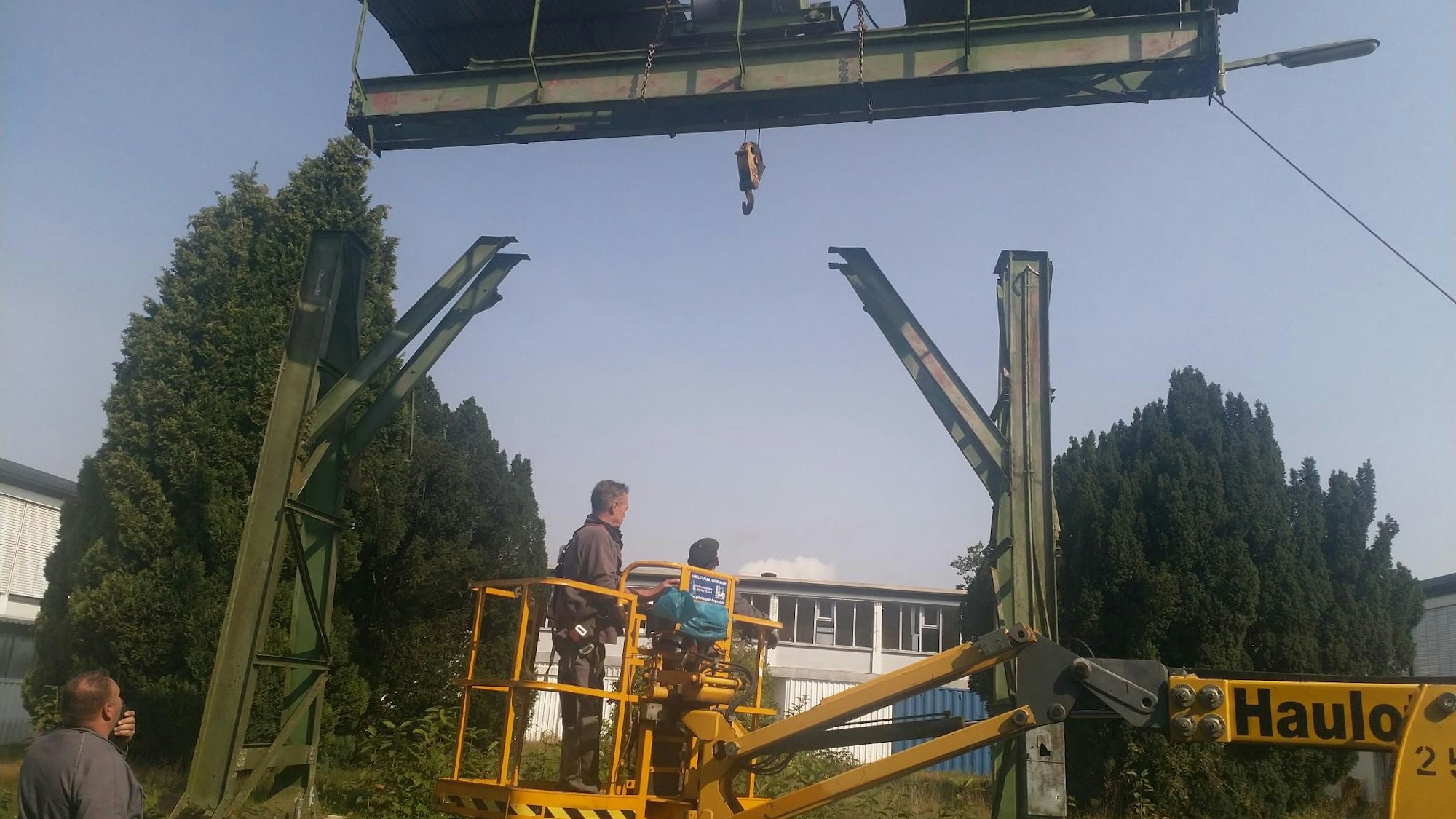 Arbeiter arbeiten von einem Hubsteiger aus am Wiederaufbau des alten Portalkrans vom Gelände des Morsbacher Bahnhofs. Der hat in Wissen an der Sieg einen neuen Platz gefunden.