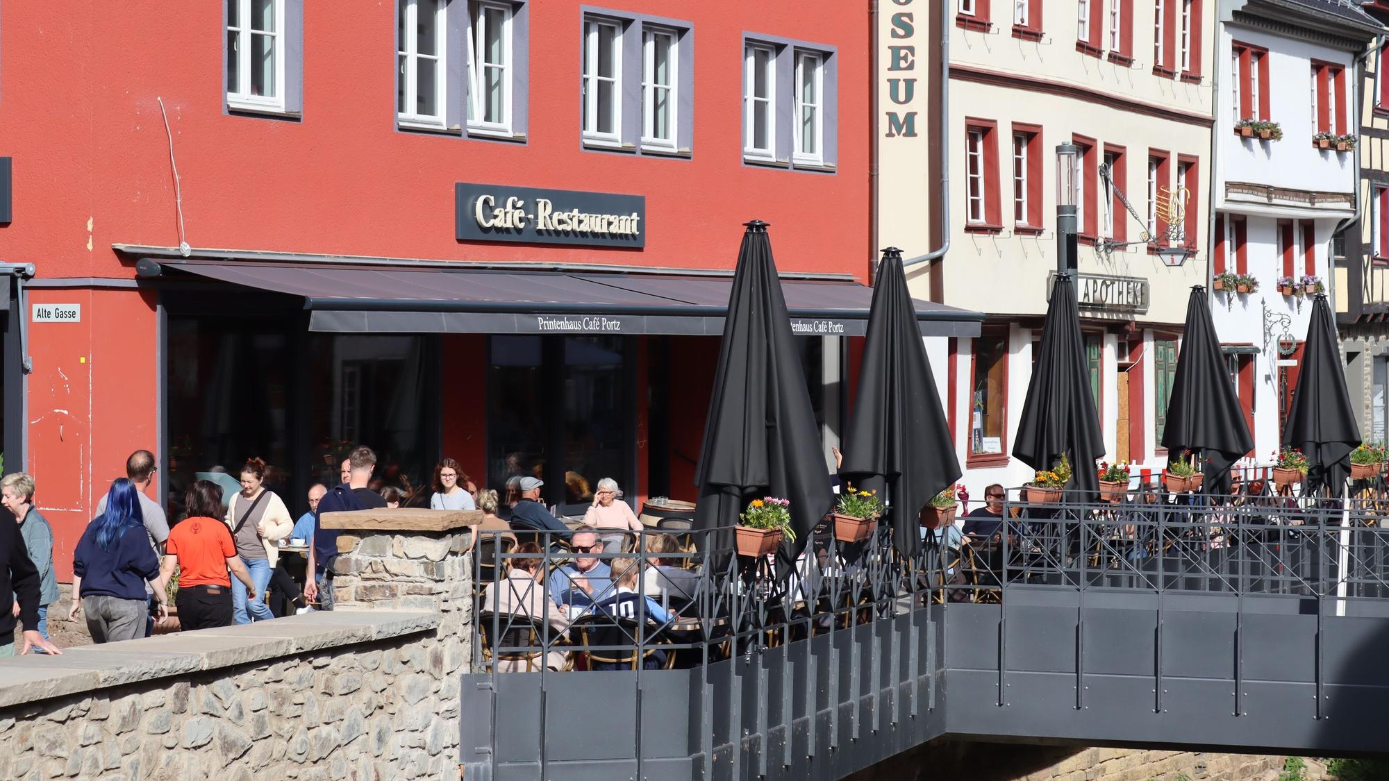 In der Bad Münstereifeler Innenstadt sitzen zahlreiche Gäste draußen an den Tischen der Gastronomiebetriebe.