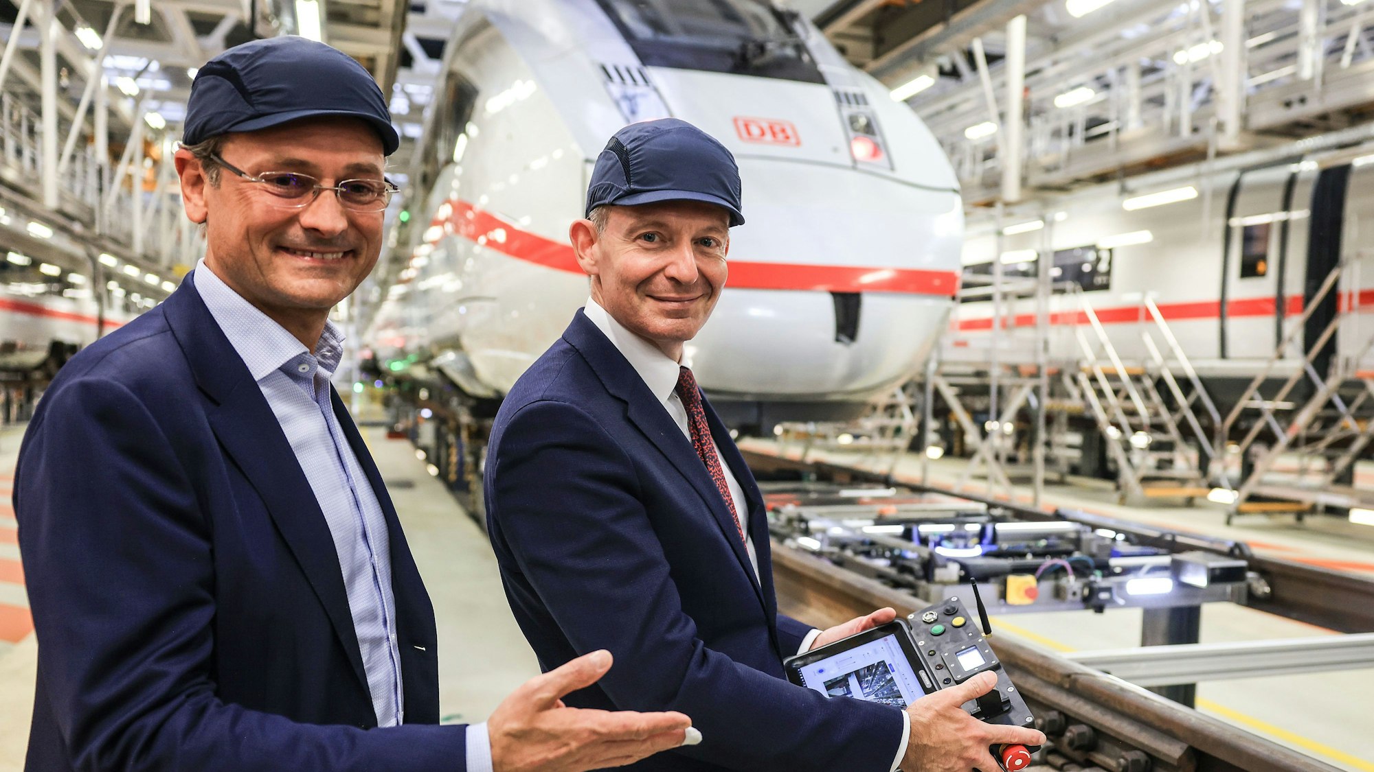Bundesverkehrsminister Volker Wissing (r, FDP), und Michael Peterson, DB-Vorstand Personenverkehr, steuern in der Wartungshalle einen Unterflurroboter.