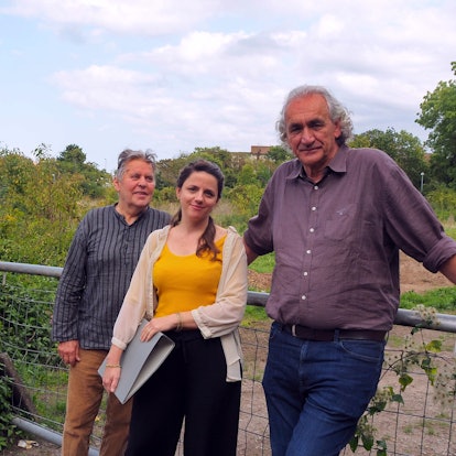 Die drei Verantwortlichen stehen vor dem Grundstück.