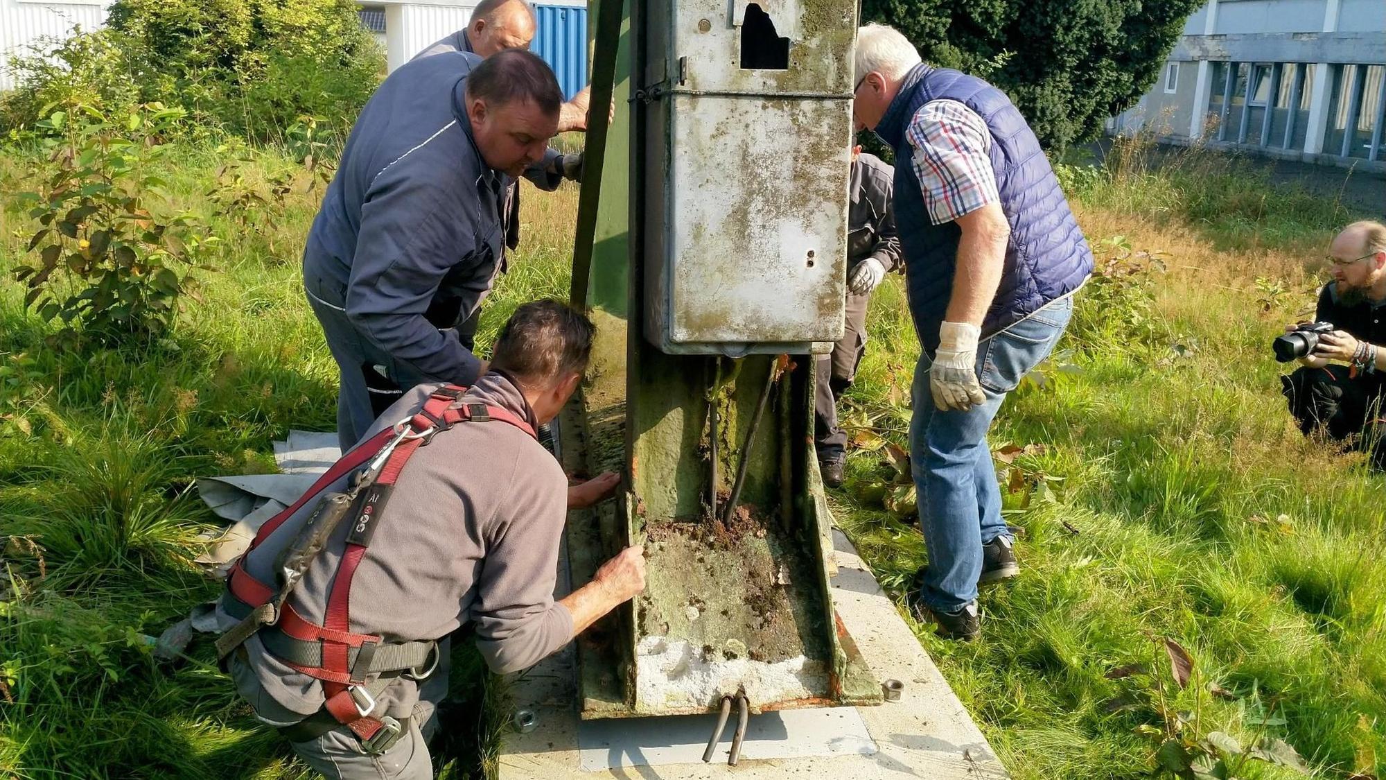 Arbeiter sorgen dafür, dass der stählerne Kran aus Morsbach wieder auf sicheren Füßen steht und besichtigt werden kann.