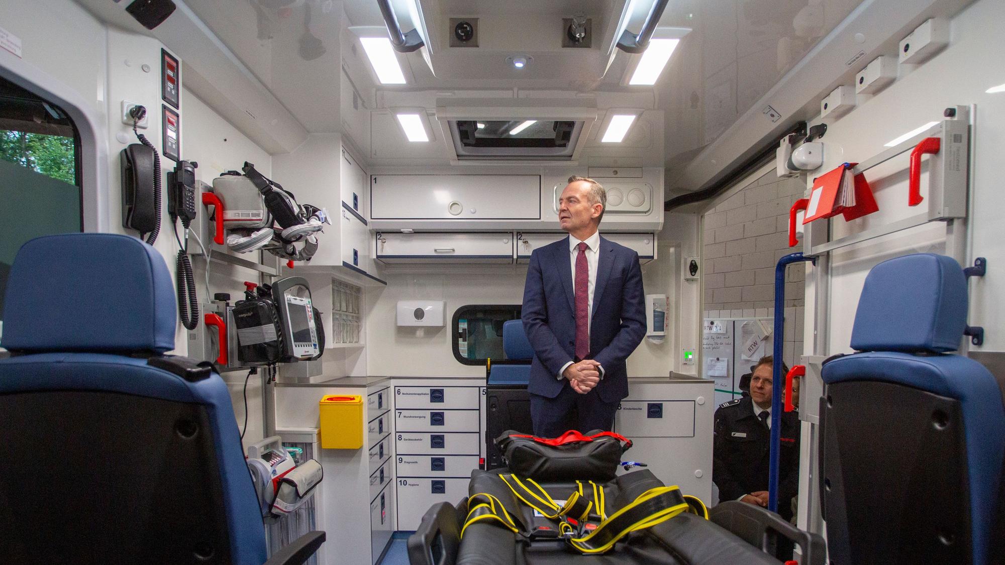 Bundesverkehrsminister Dr. Volker Wissing im ersten vom Bund geförderten E-Rettungswagen der Feuerwehr Köln vor.