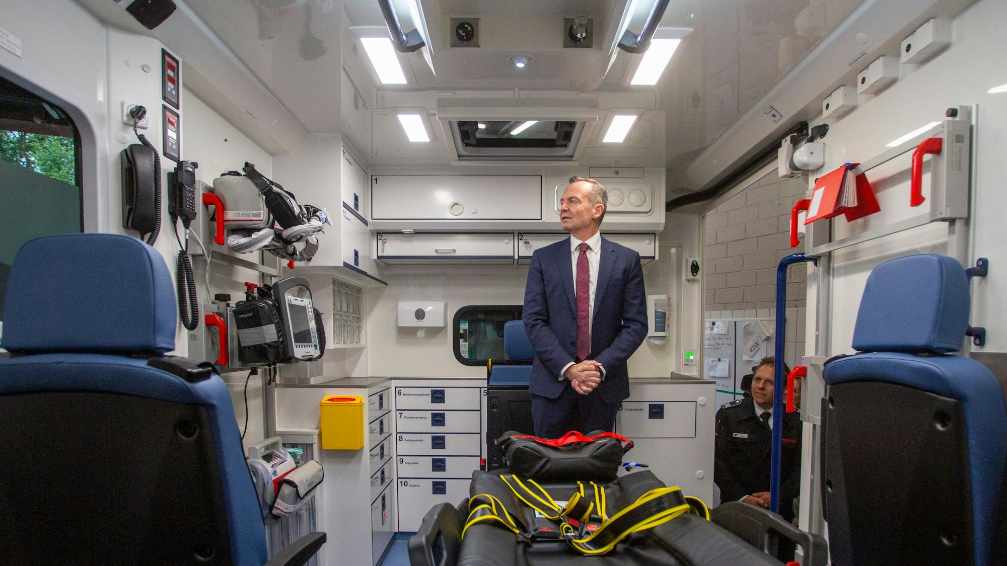 Bundesverkehrsminister Dr. Volker Wissing im ersten vom Bund geförderten E-Rettungswagen der Feuerwehr Köln vor.