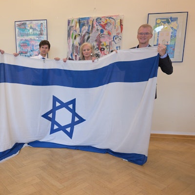 Axel Bolte, Roman Salyutov, Petra Hemming, Frank Stein stehen nebeneinander und halten eine Israel Flagge.
