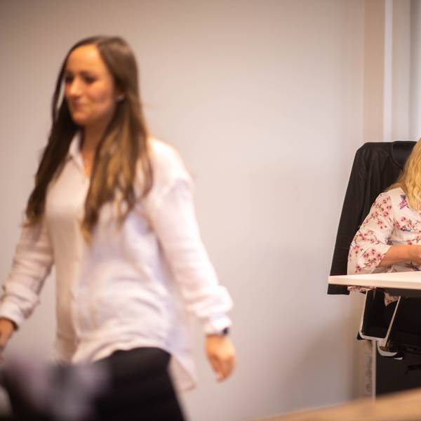 Das Bild zeigt Simone Limbach am Schreibtisch im Kreishaus. Luisa Vogelsberg verlässt gerade das Büro.