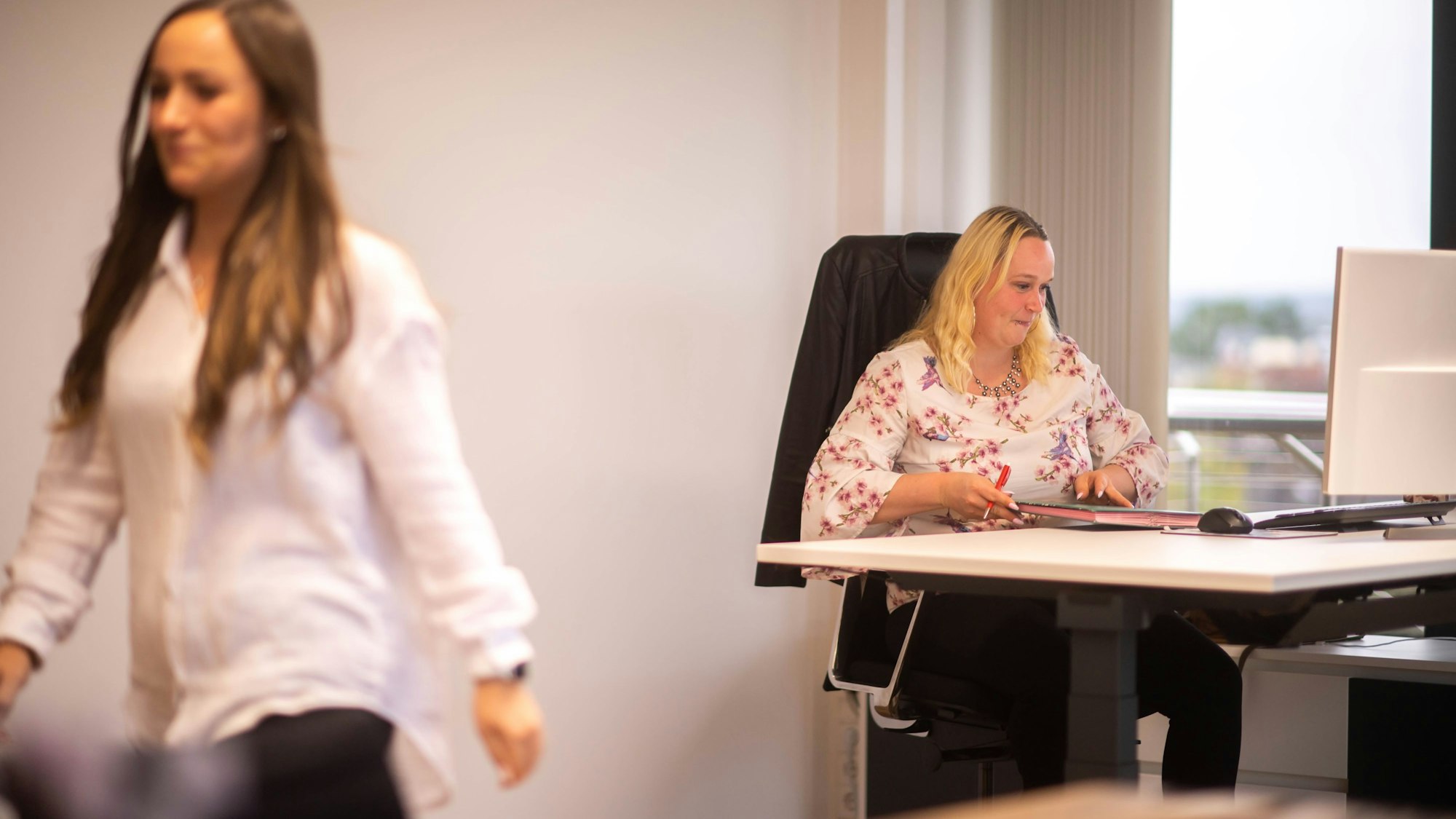 Das Bild zeigt Simone Limbach am Schreibtisch im Kreishaus. Luisa Vogelsberg verlässt gerade das Büro.