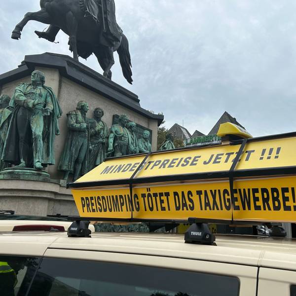 Auf einem gelben Sarg steht „Mindestpreise jetzt, Preisdumping tötet das Taxigewerbe“.