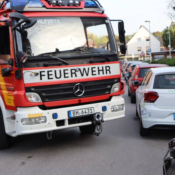 Auf dem Foto ist zu sehen, wie sich ein Feuerwehrauto an den am Straßenrand geparkten Pkw vorbeischiebt.