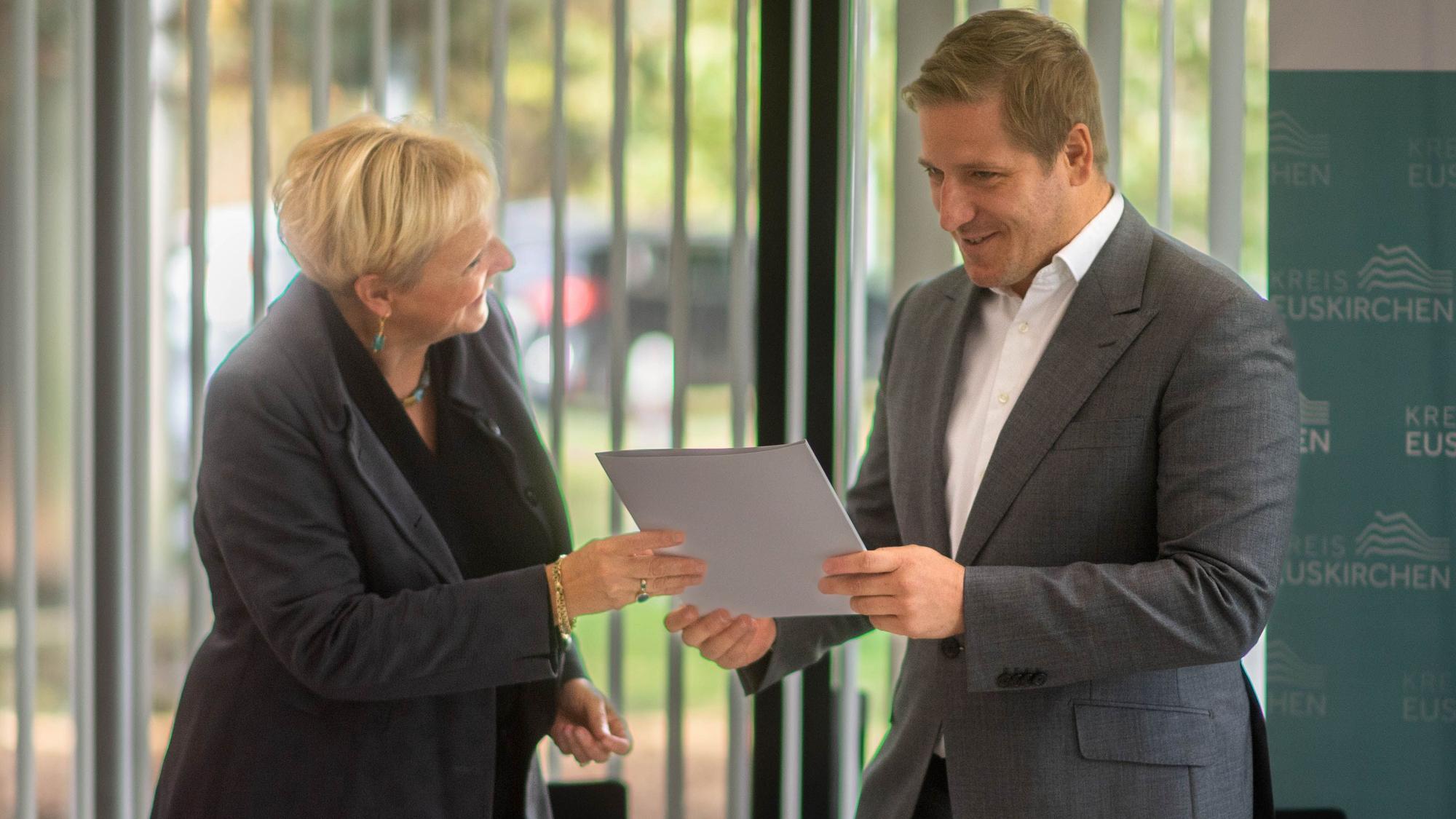 Das Bild zeigt Birgit Wonneberger-Wrede und Landrat Markus Ramers mit dem Vertrag.