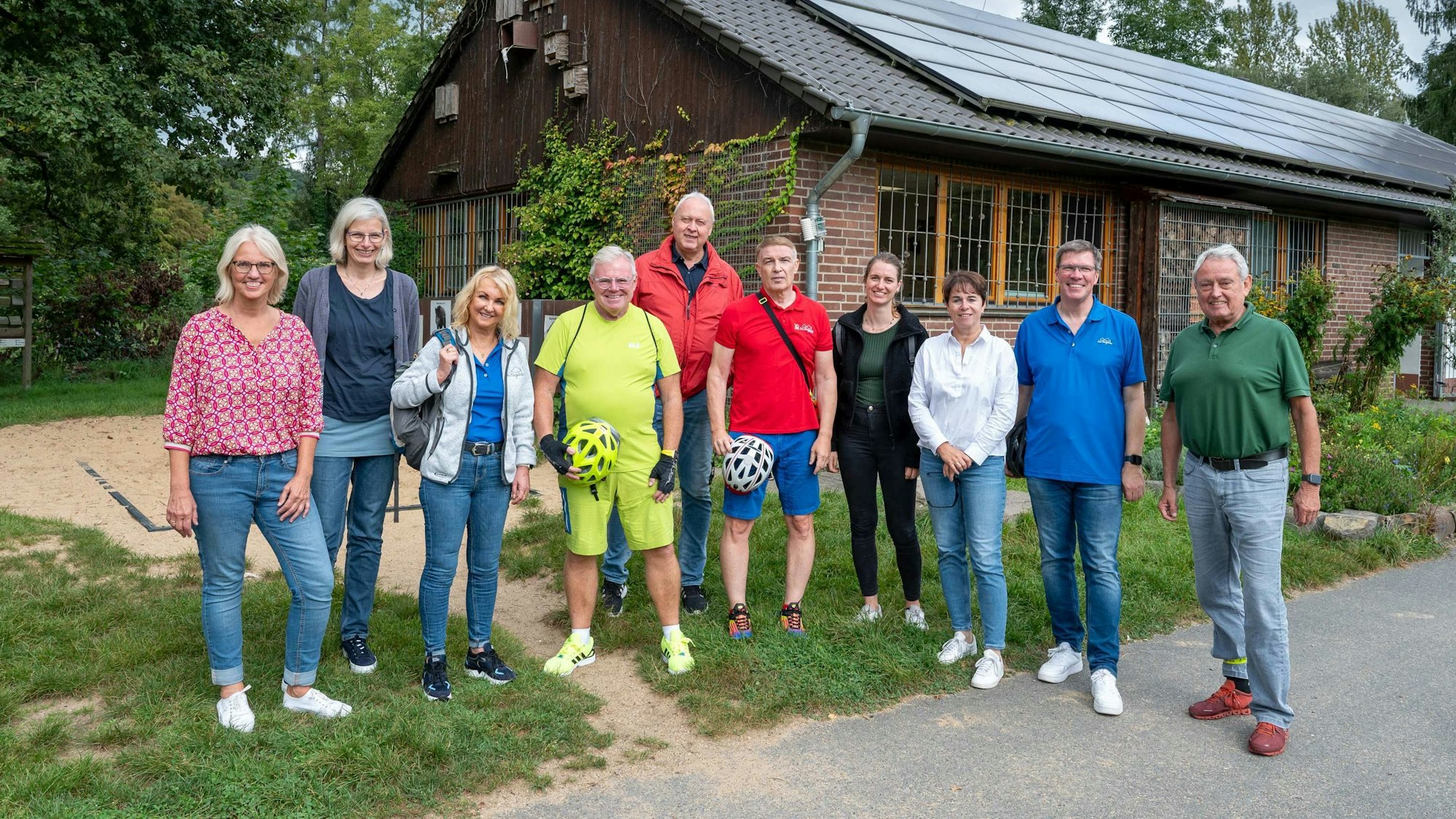 Vor der Naturschule Aggerbogen steht eine Gruppe radelnder Vertreter aus Verwaltung, Politik und Tourismus.