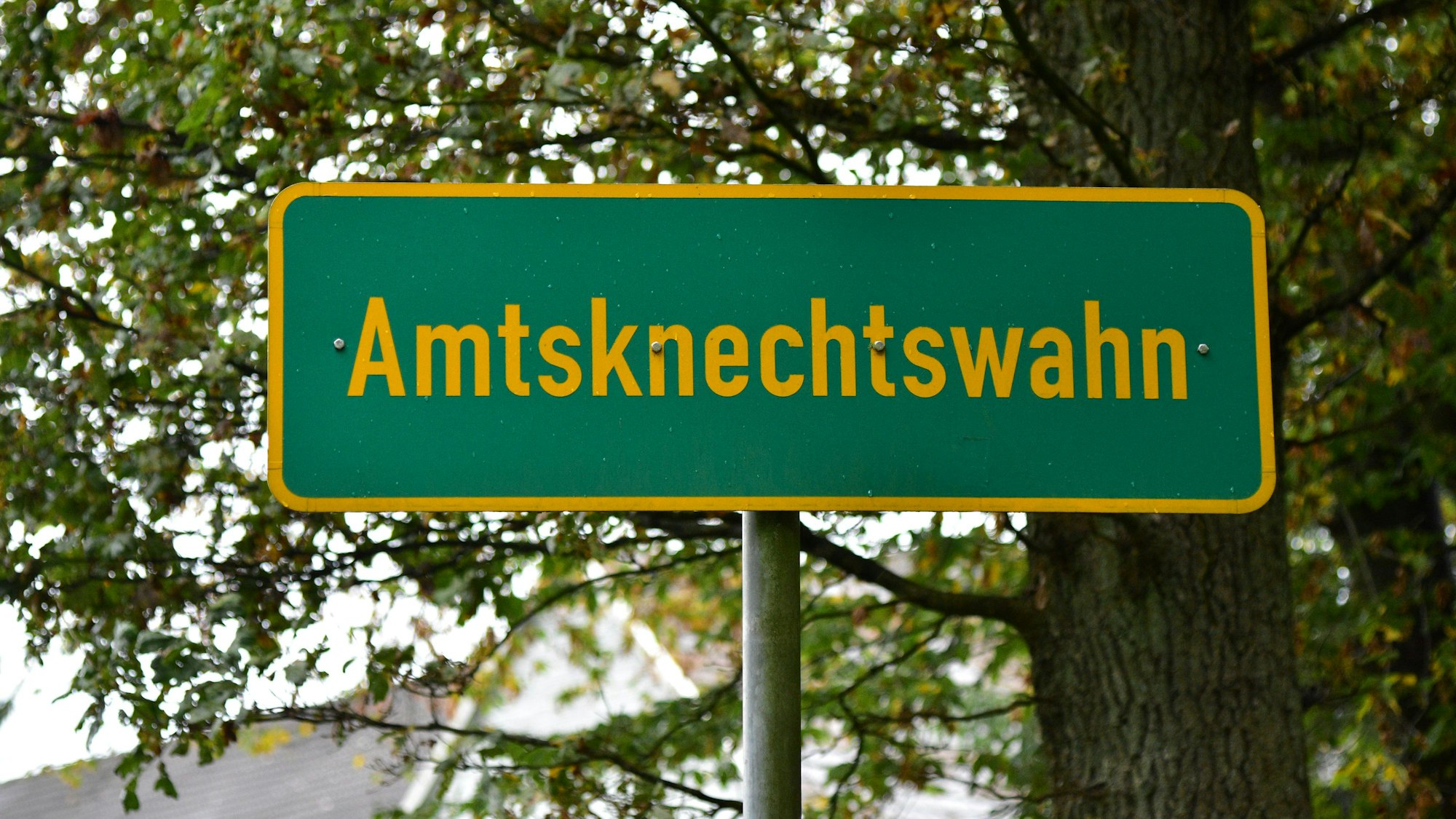 Das Bild zeigt ein grünes Ortsschild.