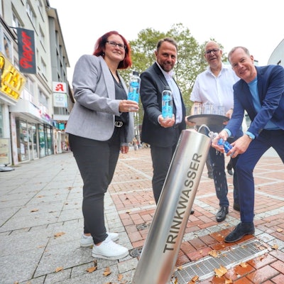 Michaela Di Padova, Uwe Richrath, Ralf Billstein und Thomas Eimermacher von der EVL am Trinkwasserbrunnen in der Wiesdorfer Fußgängerzone