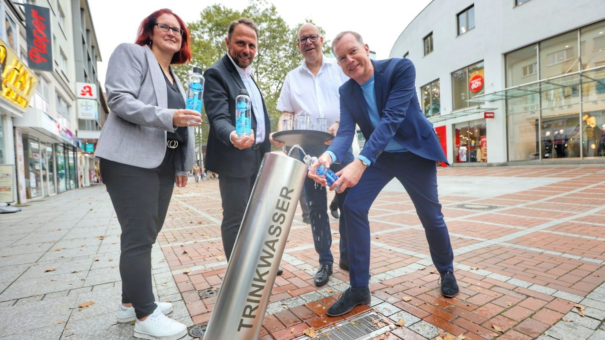 Michaela Di Padova, Uwe Richrath, Ralf Billstein und Thomas Eimermacher von der EVL am Trinkwasserbrunnen in der Wiesdorfer Fußgängerzone