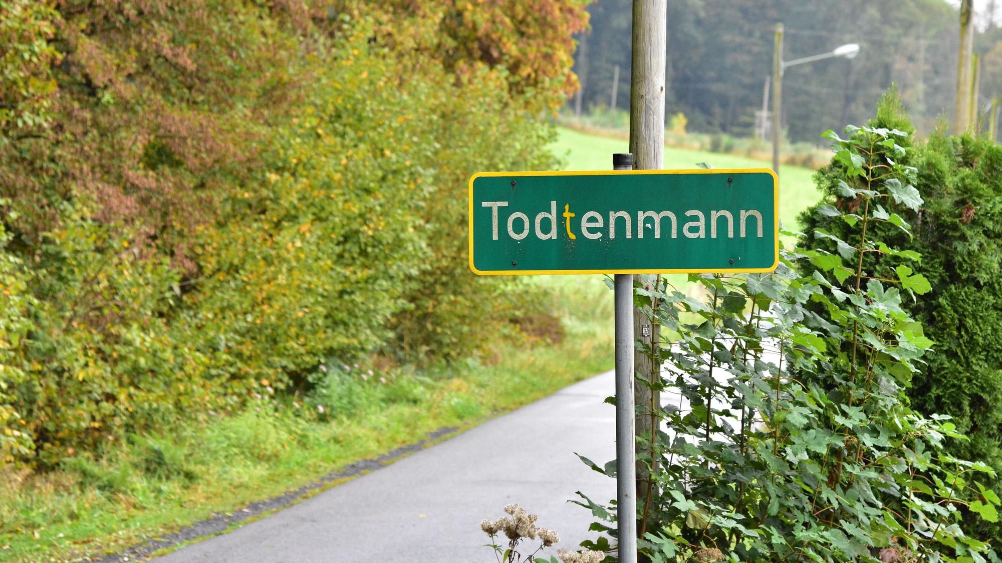 Das Bild zeigt ein grünes Ortsschild.