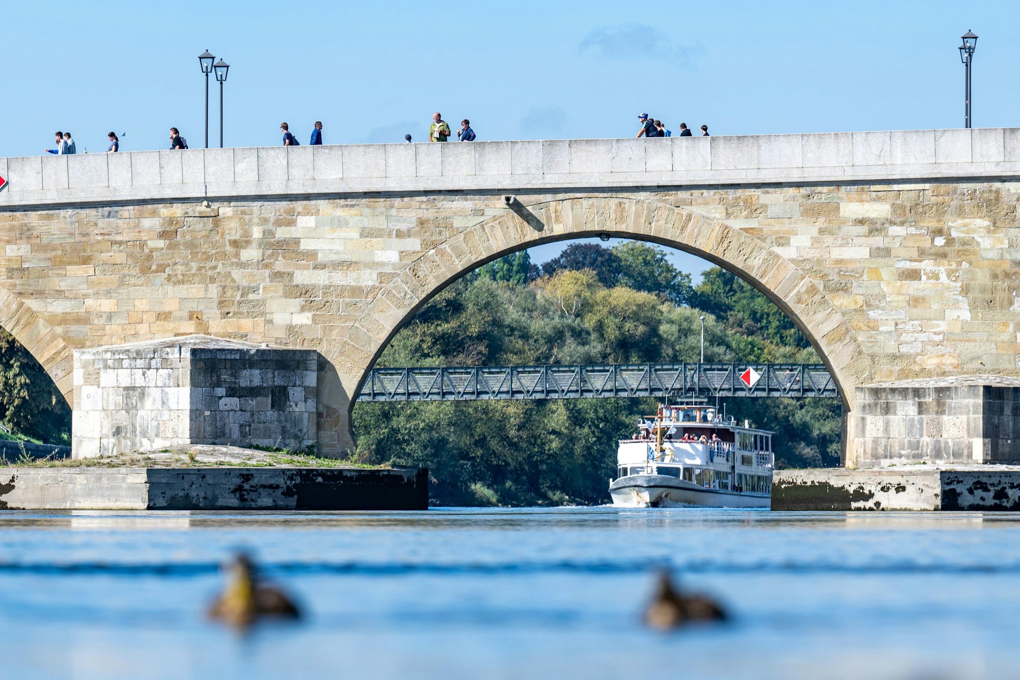 Unter der Steinernen Brücke, die über die Donau verläuft, fährt ein Schiff.(Symbolbild)