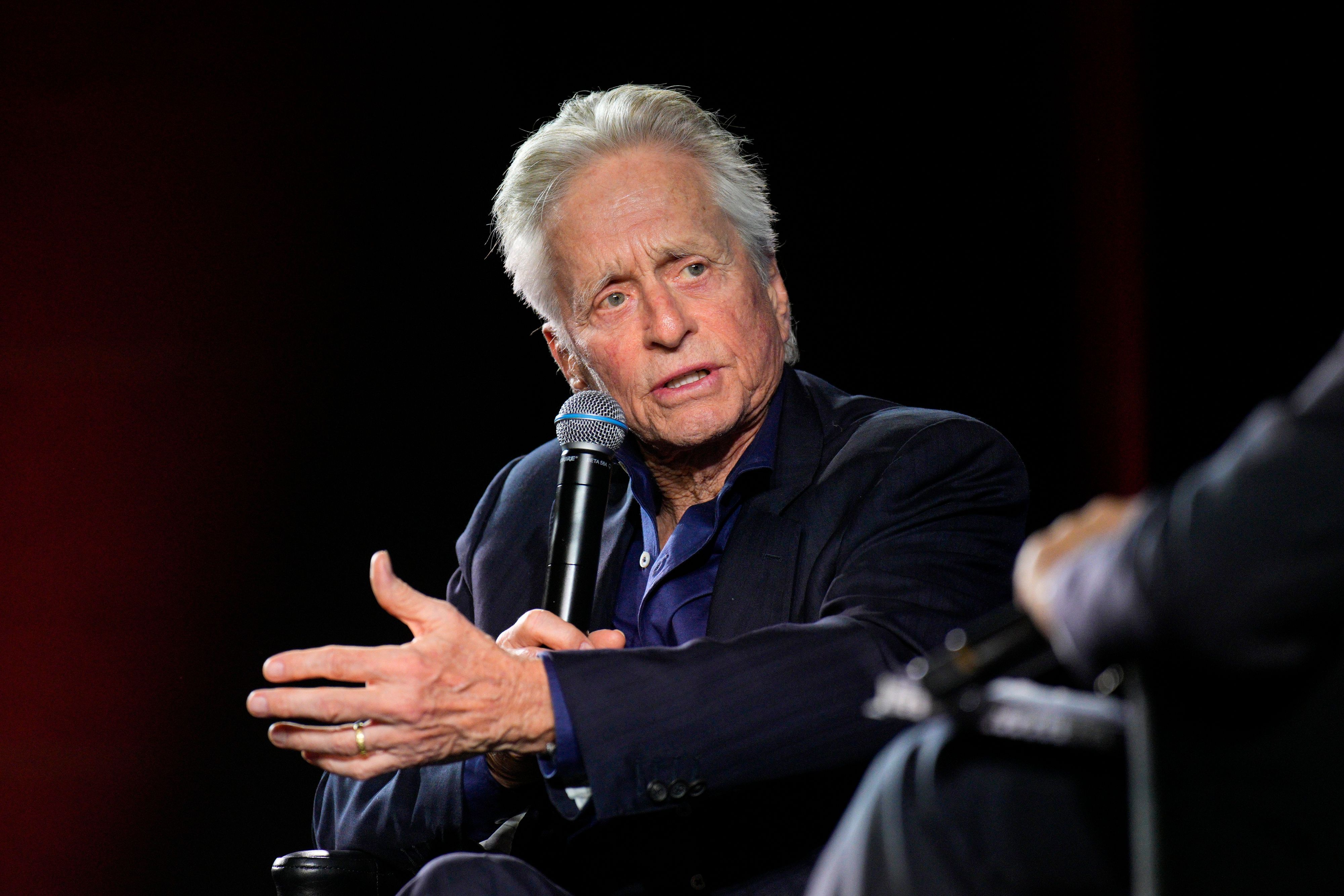 Michael Douglas (l), Schauspieler aus den USA, spricht auf der Bühne während eines Gesprächs mit dem Publikum im Rahmen der 76. Internationalen Filmfestspiele in Cannes.