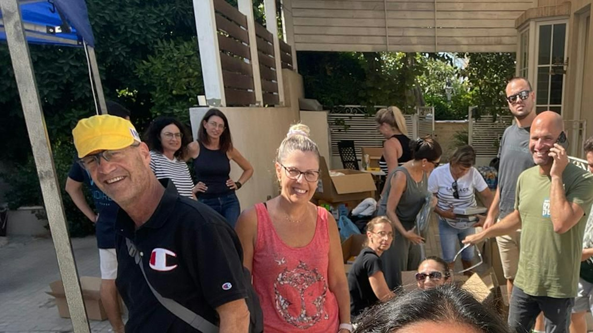 Omer Schlomowitz steht mit anderen Menschen vor einem Eingang.