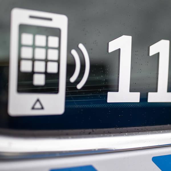 Der Nummer des Polizeinotrufs 110 steht auf der Scheibe eines Polizeifahrzeugs.