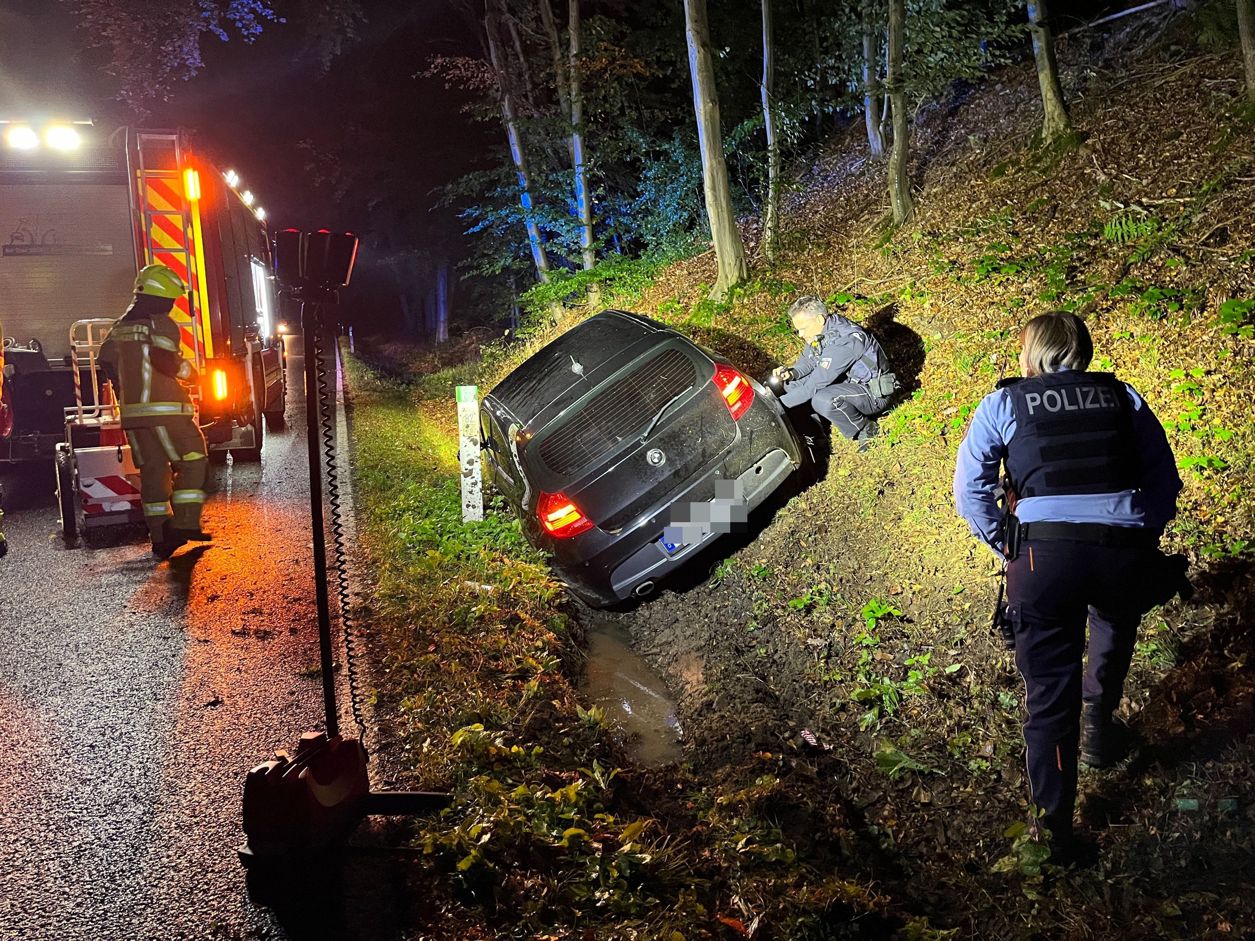 Eine 29 Jahre alte Frau aus Lohmar ust mit ihrem Auto in den Straßengraben gefahren und leicht verletzt worden. Polizisten sichern Spuren, die Feuerwehr leuchtete die Unfallstelle aus.