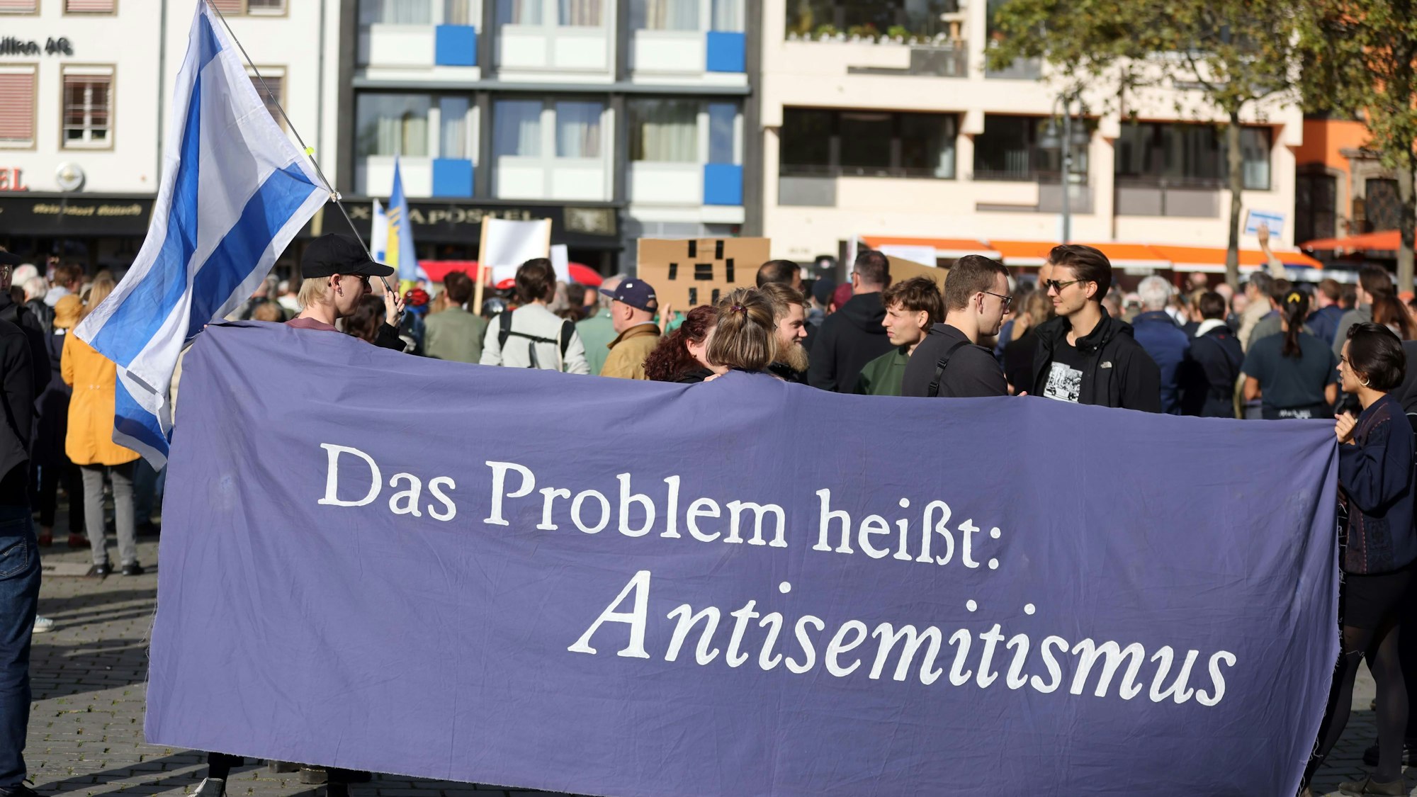 Demonstranten halten ein Banner mit der Aufschrift „Das Problem heißt: Antisemitismus“ hoch.