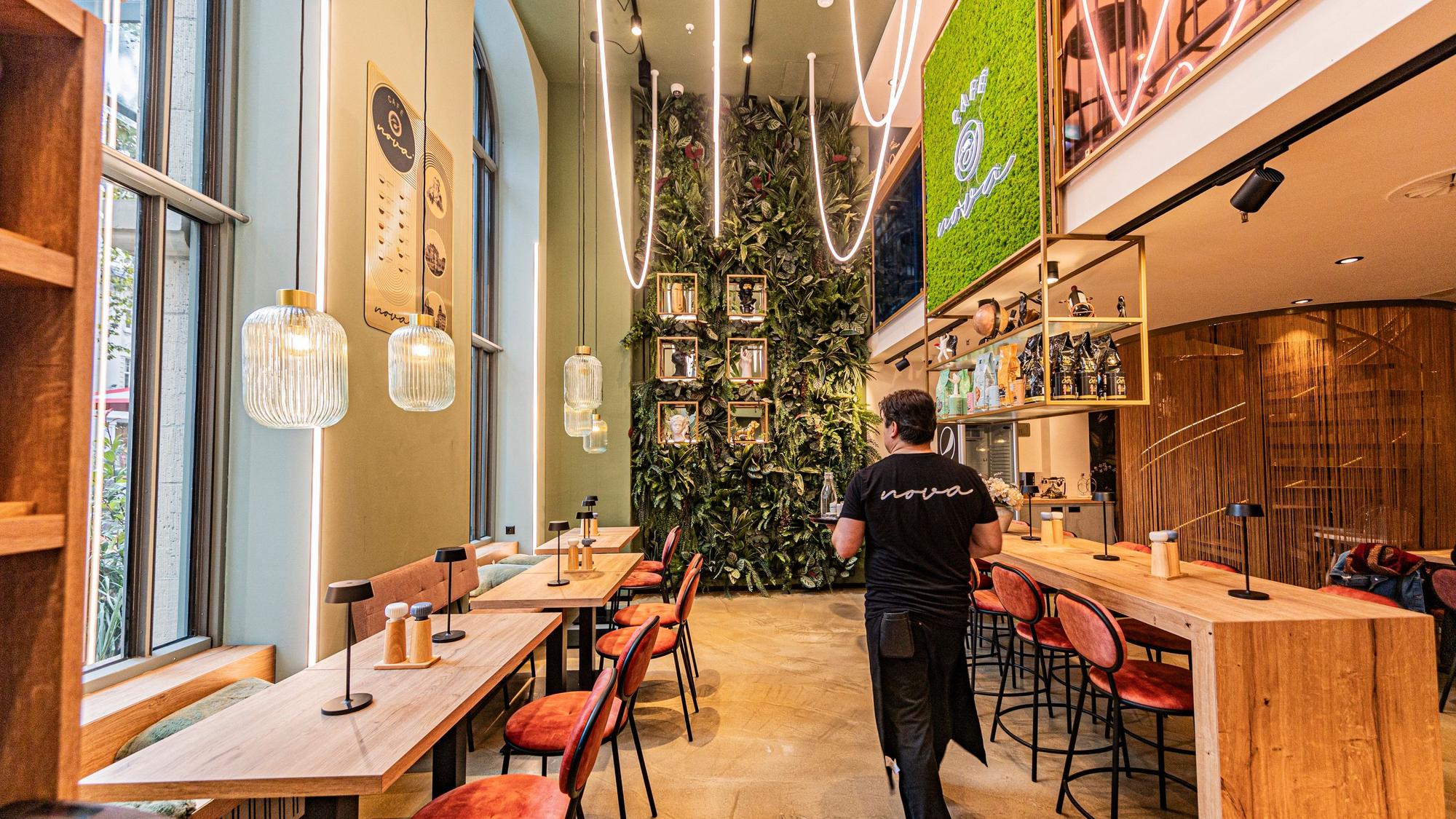 Ein Kellner geht durch das neue Cafe Nova in Bonn.
