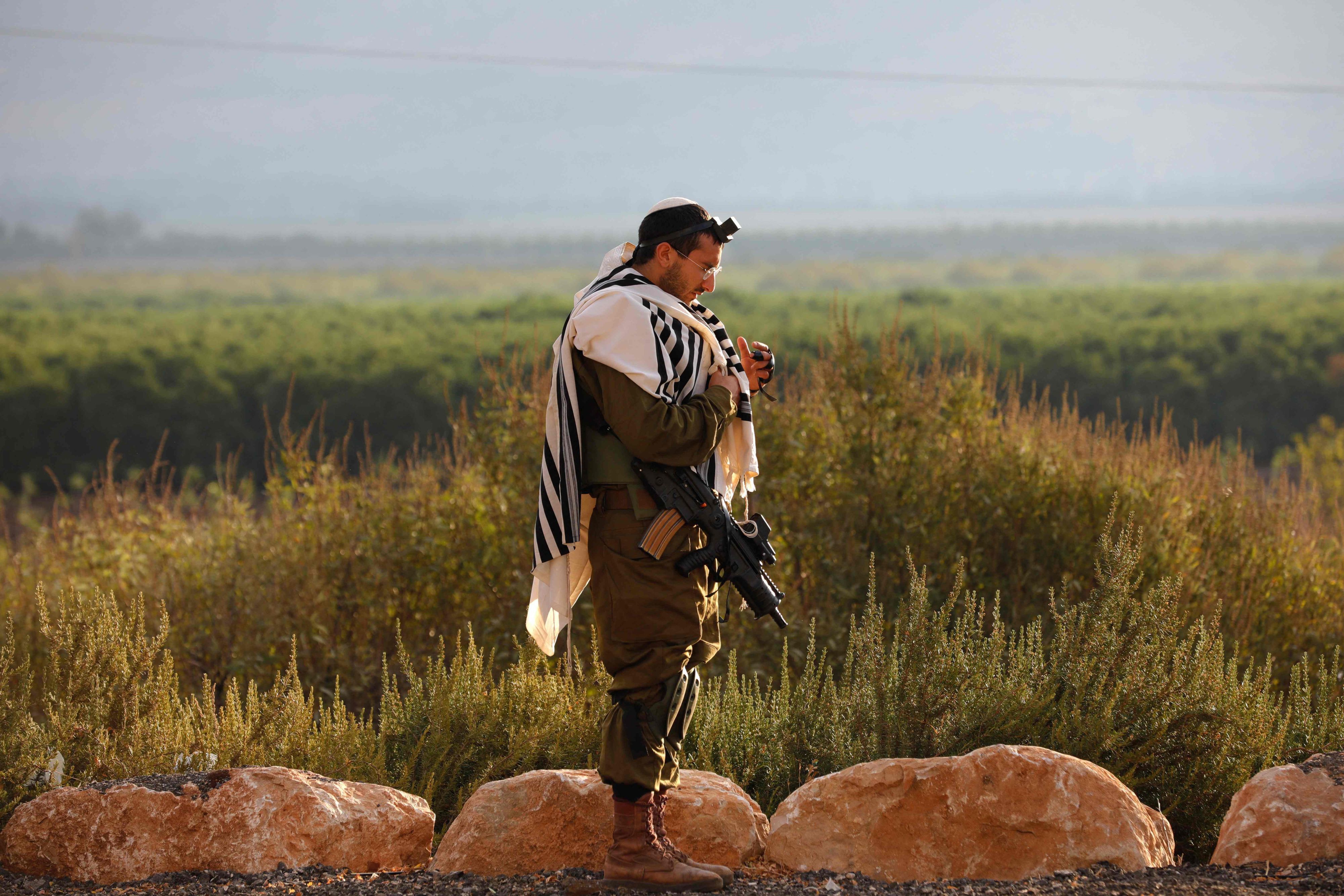Ein israelischer Soldat, der Tefillin (Phylakterien) trägt, eine kleine schwarze Lederschatulle, die Pergamentrollen mit Versen aus der Tora enthält, betet am 15. Oktober 2023 in einer Militärposition im Norden Israels nahe der Grenze zum Libanon.