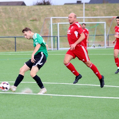 Ein Schöneseiffener Fußballspieler schießt den Ball, der Kalk der Strafraumlinie springt hoch. Der Zülpicher Verteidiger kommt zu spät.