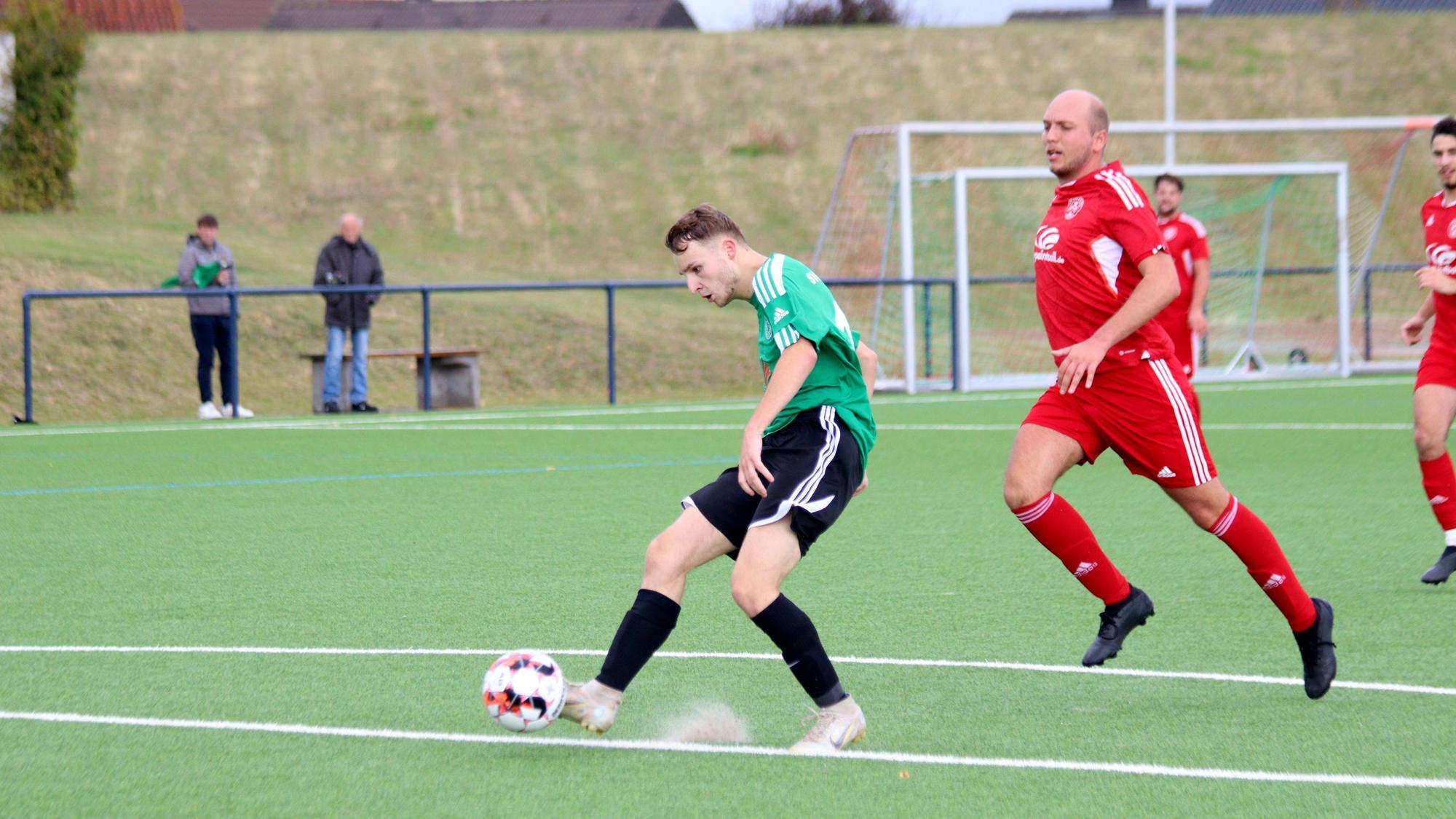 Ein Schöneseiffener Fußballspieler schießt den Ball, der Kalk der Strafraumlinie springt hoch. Der Zülpicher Verteidiger kommt zu spät.