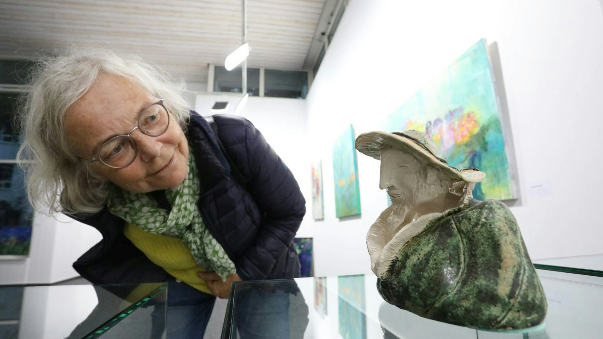 Eine Besucherin betrachtet eine Keramik von Wiltrud Bartmann im Kunstraum.