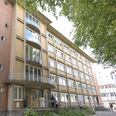 Ein Bürohaus aus den 1950er Jahren mit breiten Fensterfronten, Bullaugen und geschwungenen Balustraden.