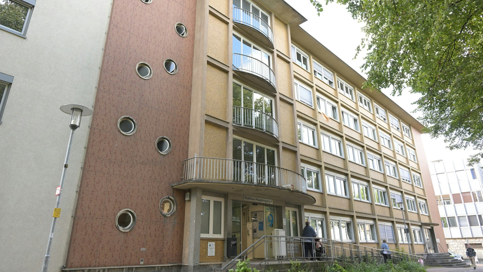 Ein vierstöckiges Verwaltungsgebäude aus den 1950er Jahren, mit langen Fensterbändern und geschwungenen Balkonen.