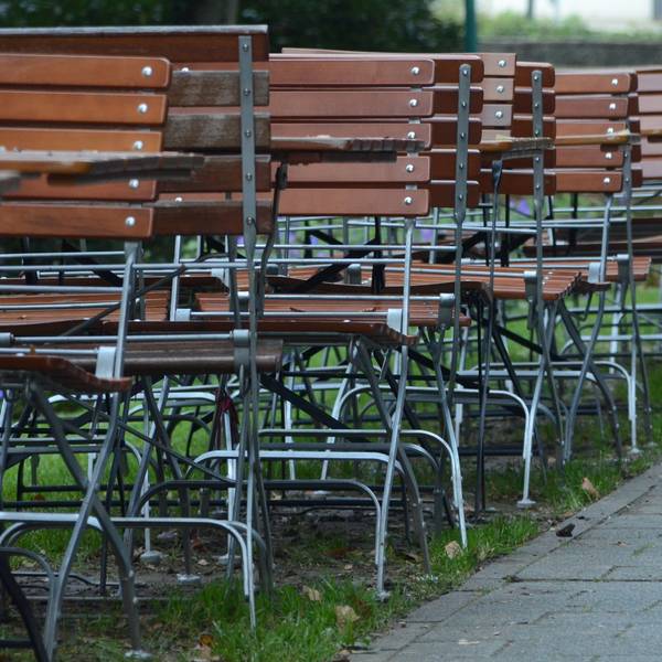 Kneipenstühle stehen an einer Straße.